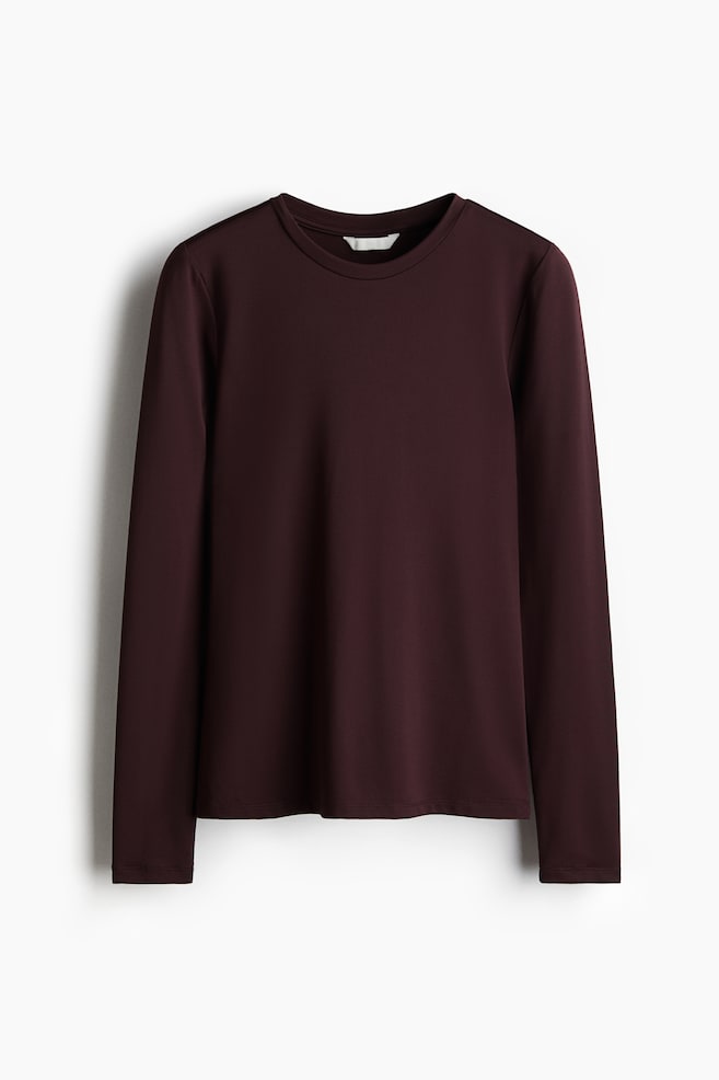 Ein eng anliegendes, dunkelburgunderfarbenes Langarmshirt aus weichem Jersey mit einem schmalen Besatz um den runden Halsausschnitt wird von VORNE präsentiert. - 1