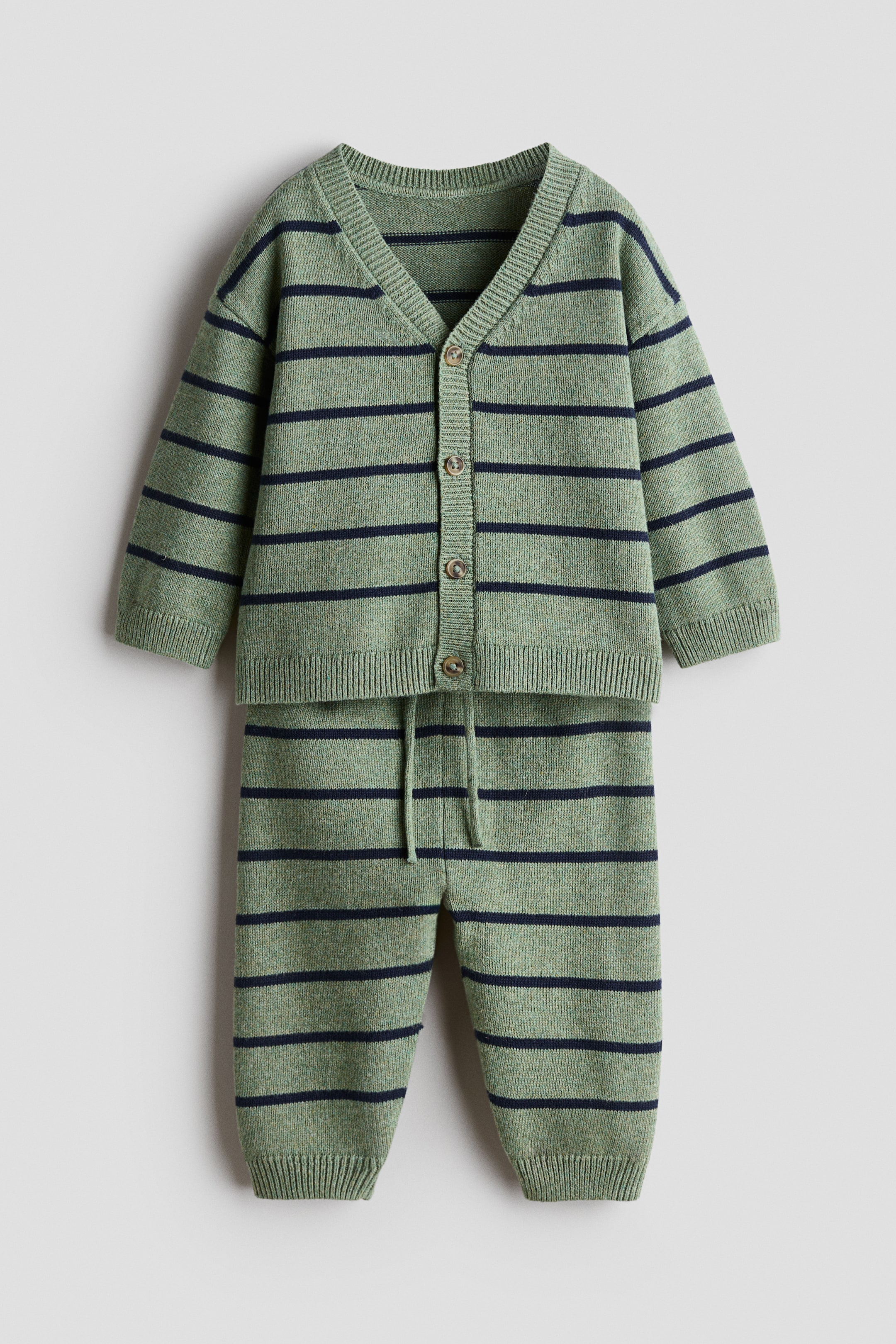 Größeres Bild ansehen: Ein zweiteiliges Set, das von vorne präsentiert wird, zeigt eine grün-blau gestreifte Strickjacke mit V-Ausschnitt, Knopfleiste vorne und gerippten Bündchen sowie Saum. Die dazu passenden Hosen verfügen über einen verstellbaren Kordelzug in der Taille und gerippte Säume.