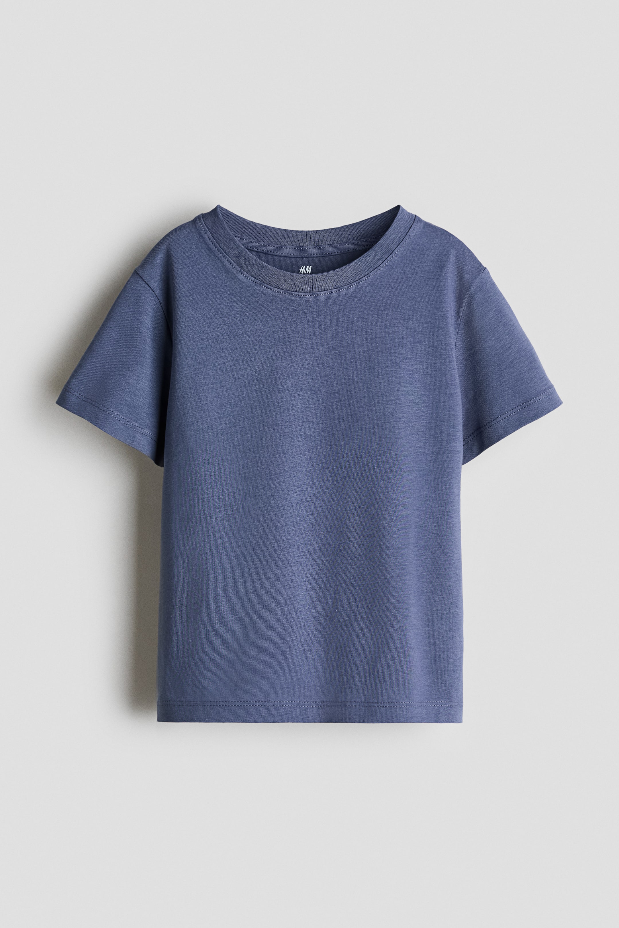 Grotere afbeelding bekijken: Een T-shirt van zachte katoenen jersey staat naar voren gericht en toont een effen blauwe kleur. Het heeft een ronde hals met geribde afwerking, korte mouwen en een rechte zoom.