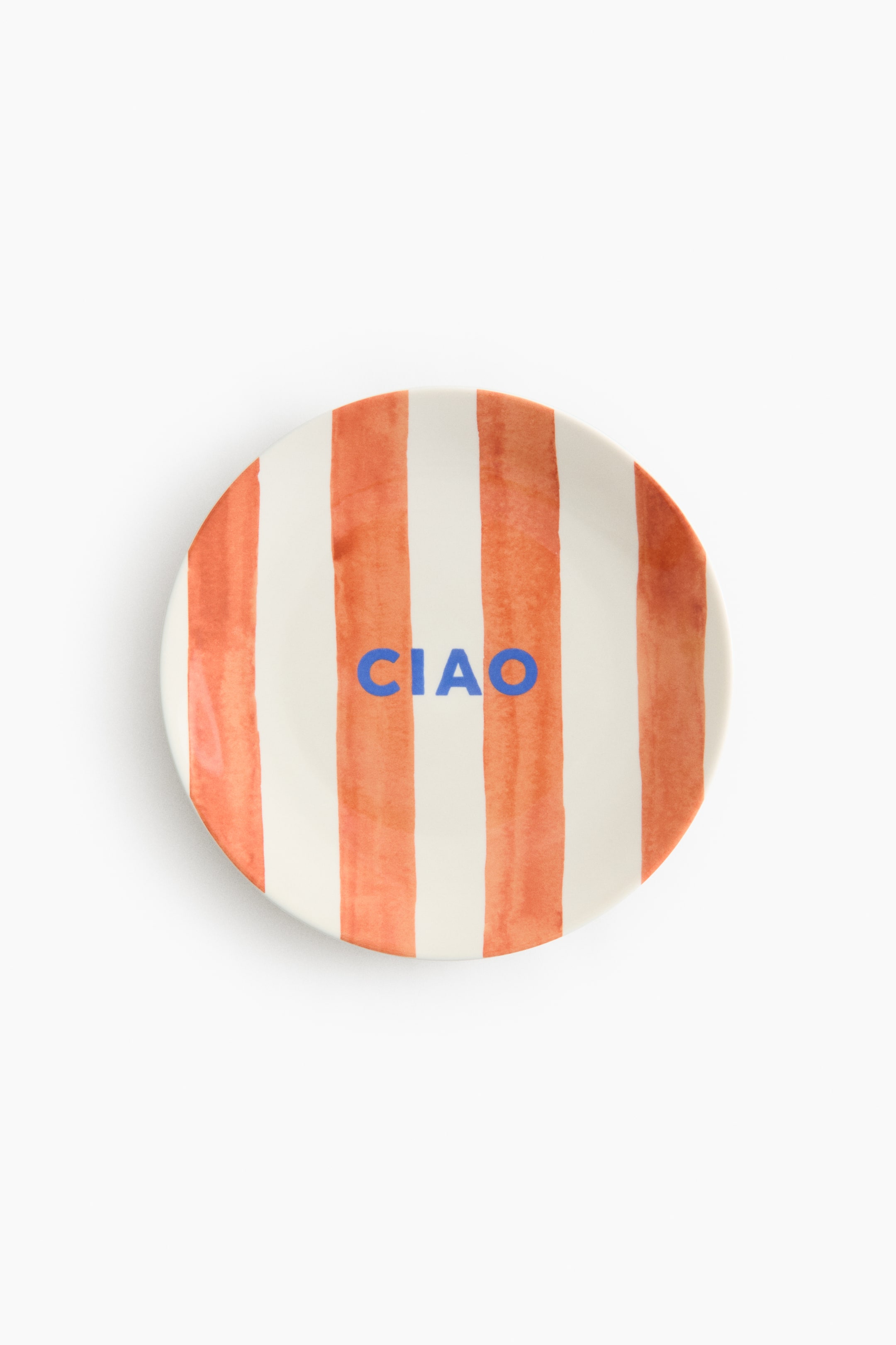 View larger image: A medium porcelain plate, facing front, displays vertical orange stripes on an off-white background, with the word "CIAO" printed centrally in blue capital letters.