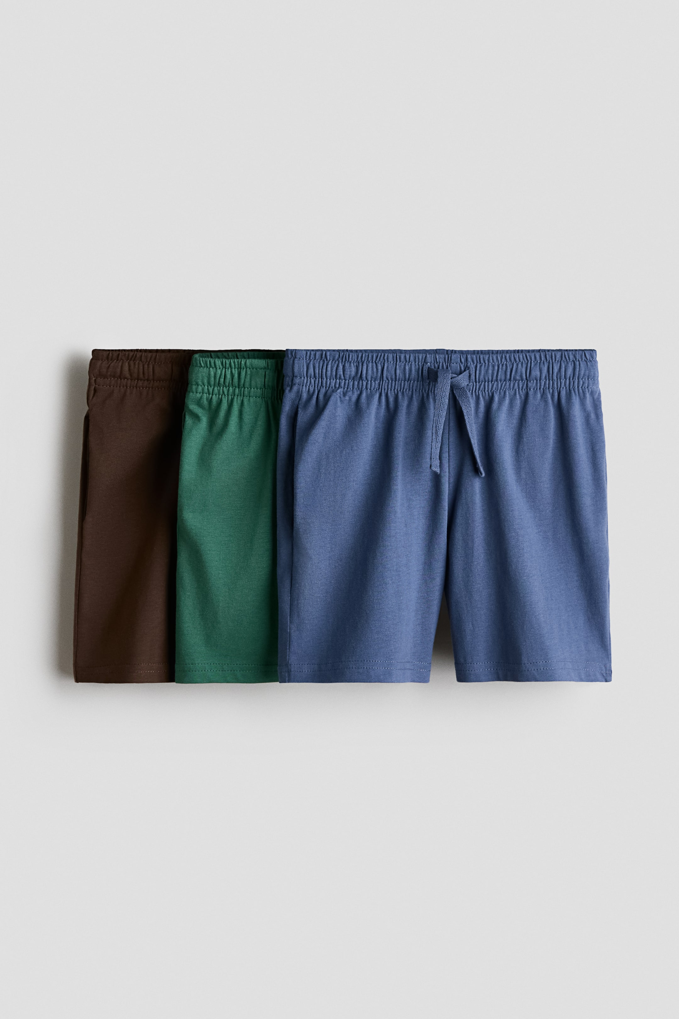 View larger image: Three pairs of shorts in soft cotton jersey with an elasticized drawstring waist are shown from the front. The shorts are available in brown, green, and blue.
