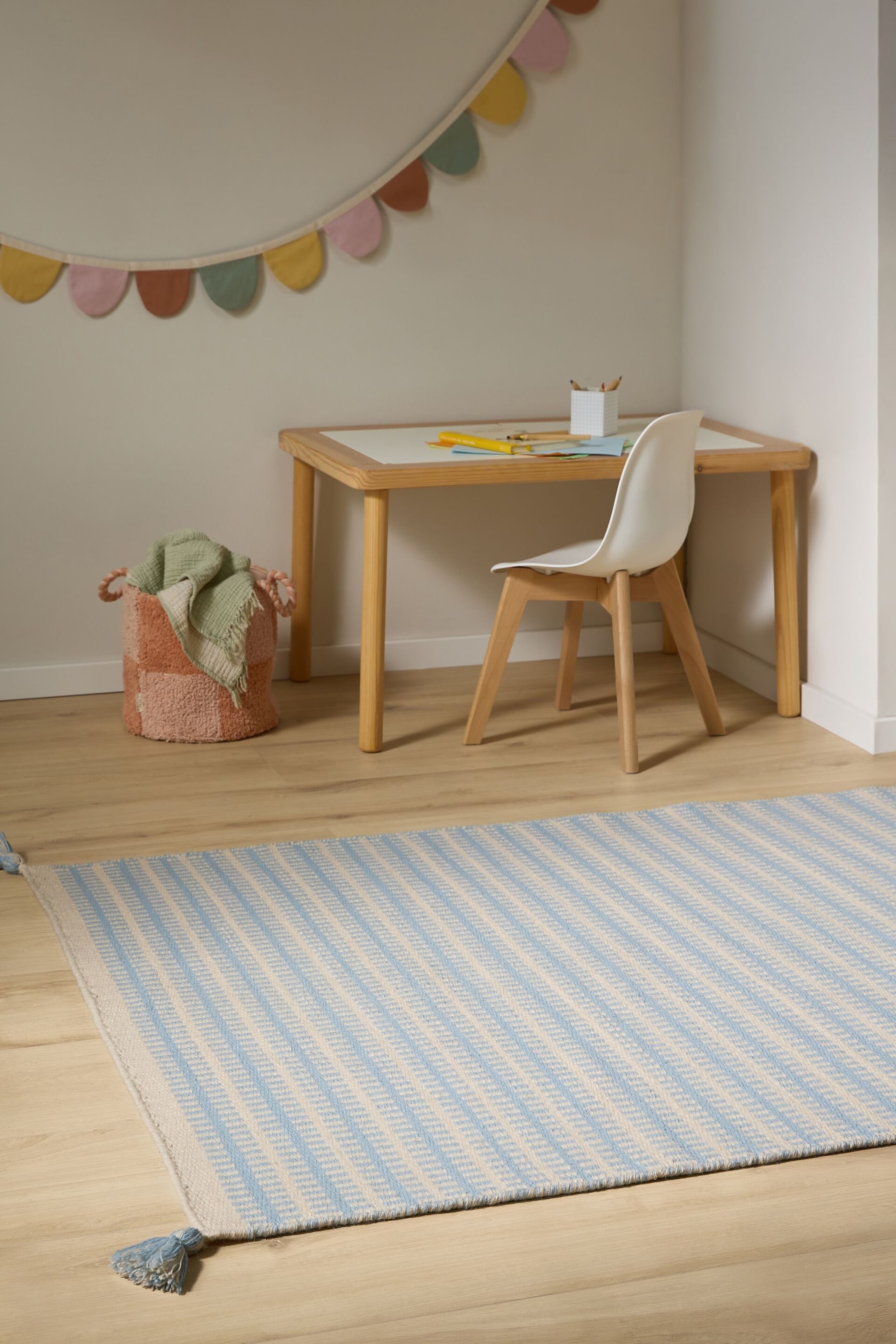 Visa större bild: Den rektangulära mattan har ljusblå och benvita diagonala ränder, skapade med en chevronväv, och ljusblå tofsar syns i båda ändar.