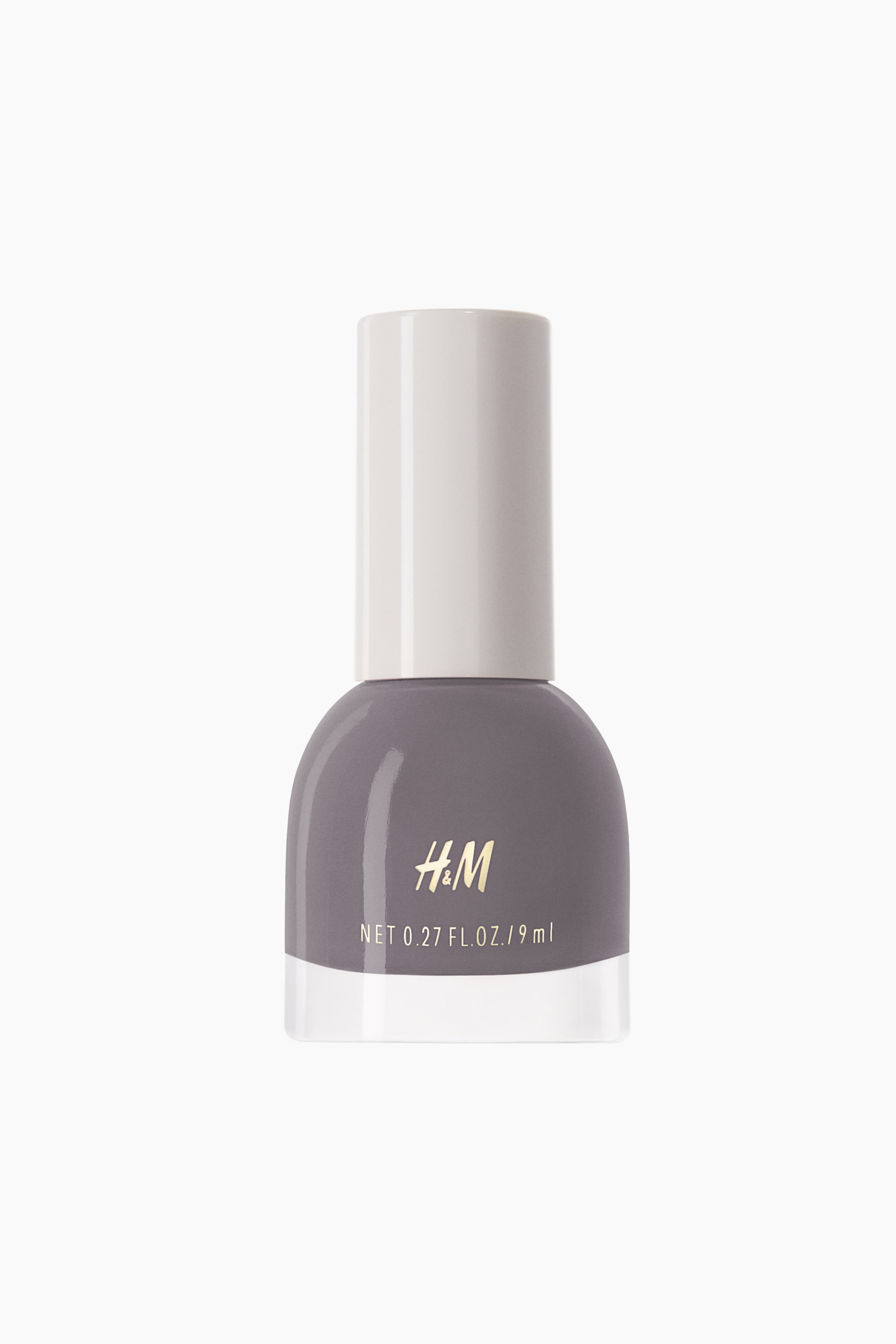 View larger image: The nail polish comes in a bell-shaped bottle, featuring a subtle purple-gray hue, and is capped with a light off-white cylindrical top. The front of the bottle showcases "H&M" in gold lettering, along with the volume "NET 0.27 FL. OZ. / 9 ml" in white.