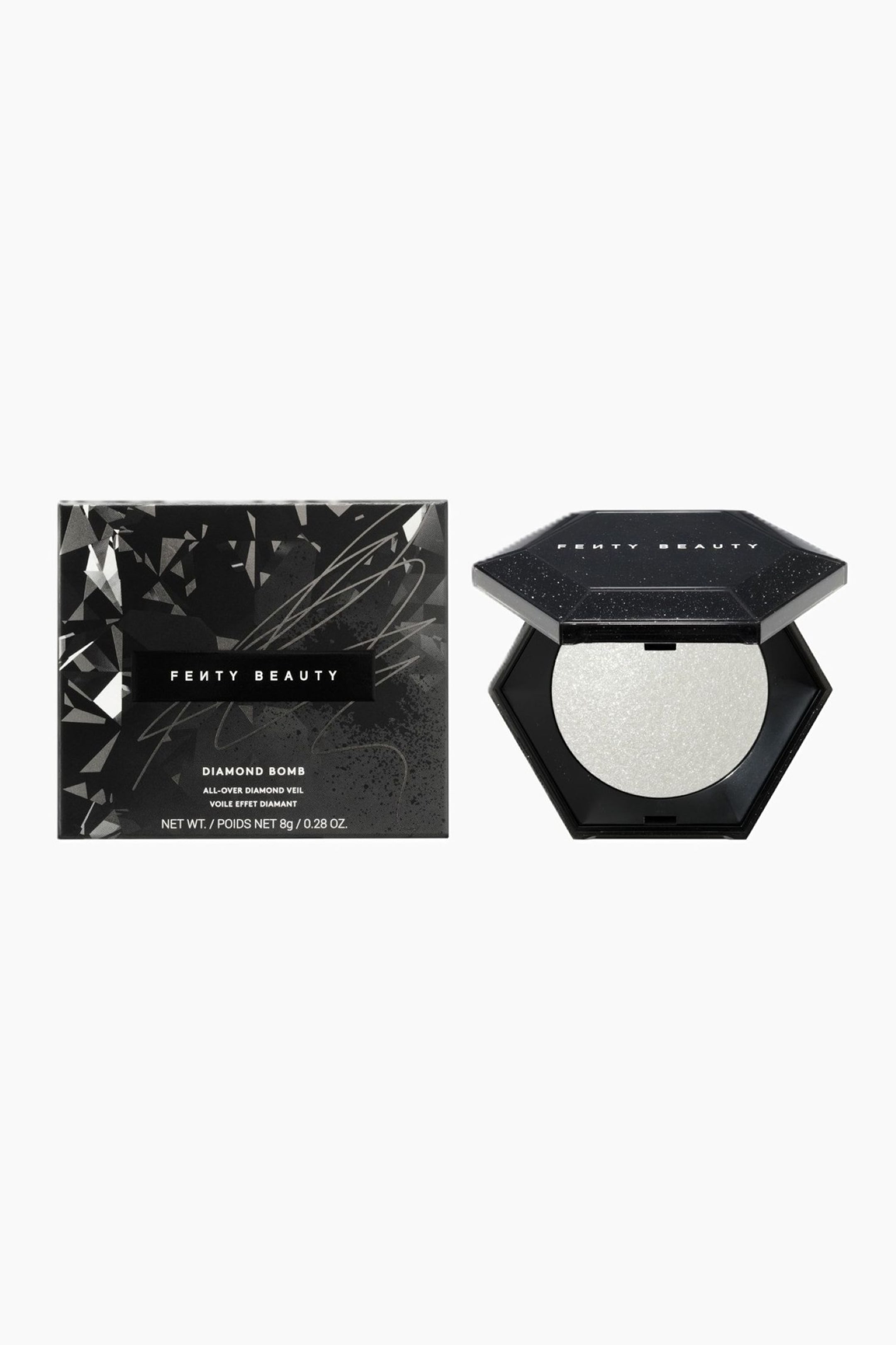 Visa större bild: Limited Edition Diamond Bomb All-over Diamond Veil visas i en frontalt vinklad vy, där dess svarta fyrkantiga förpackningsask visas bredvid den öppnade compacten. Asken har ett facetterat, geometriskt diamantmönster med silverdetaljer, medan den öppna, sexkantiga svarta glittriga compacten visar en rund panna med skimrande, silvervit puderhighlighter.