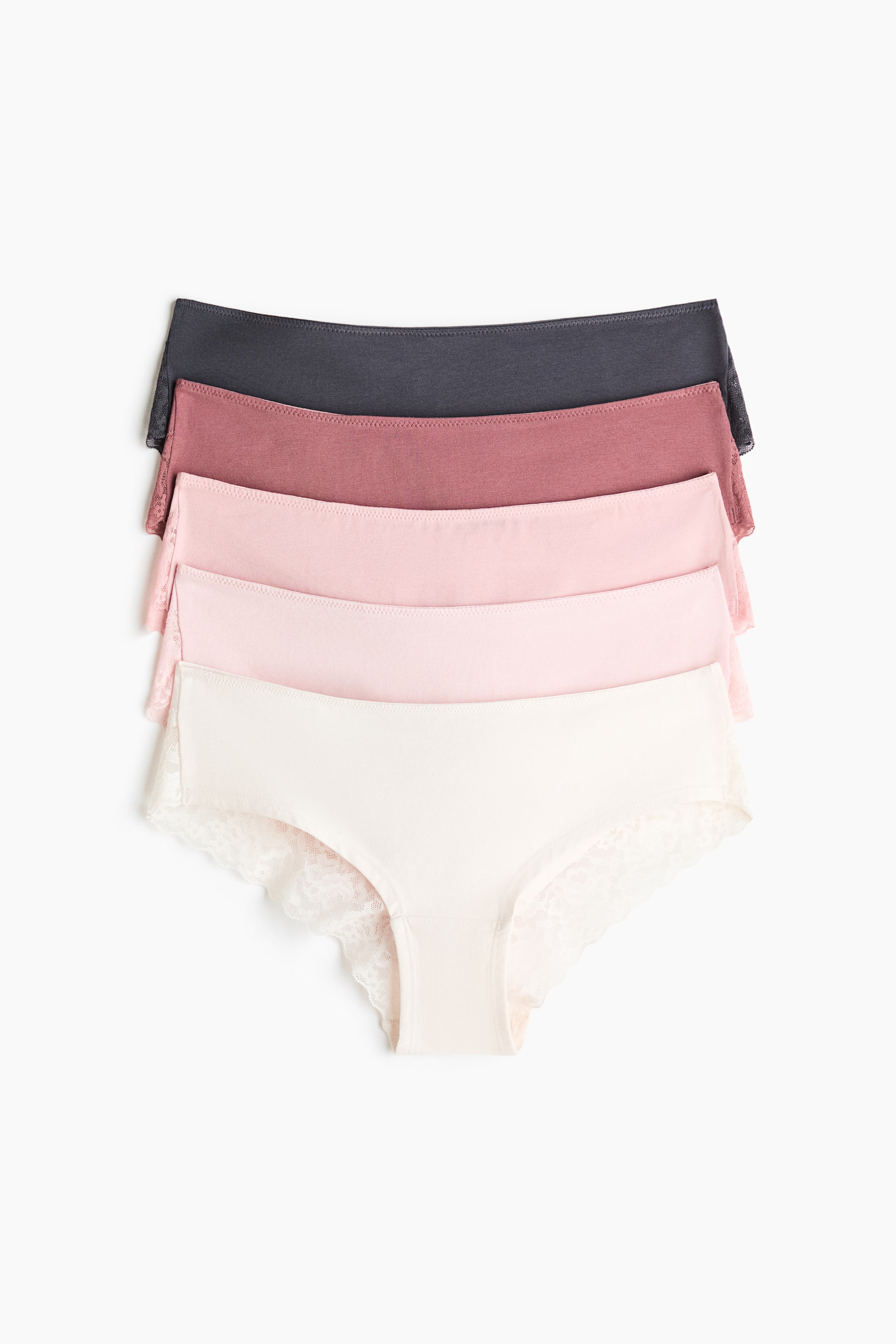 Agrandir l'image: Cinq culottes hipster sont présentées de face, empilées dans un dégradé de tons doux allant du gris foncé au crème. Chaque culotte est confectionnée en jersey lisse avec une délicate bordure en dentelle le long des ouvertures des jambes et une coupe taille mi-haute.