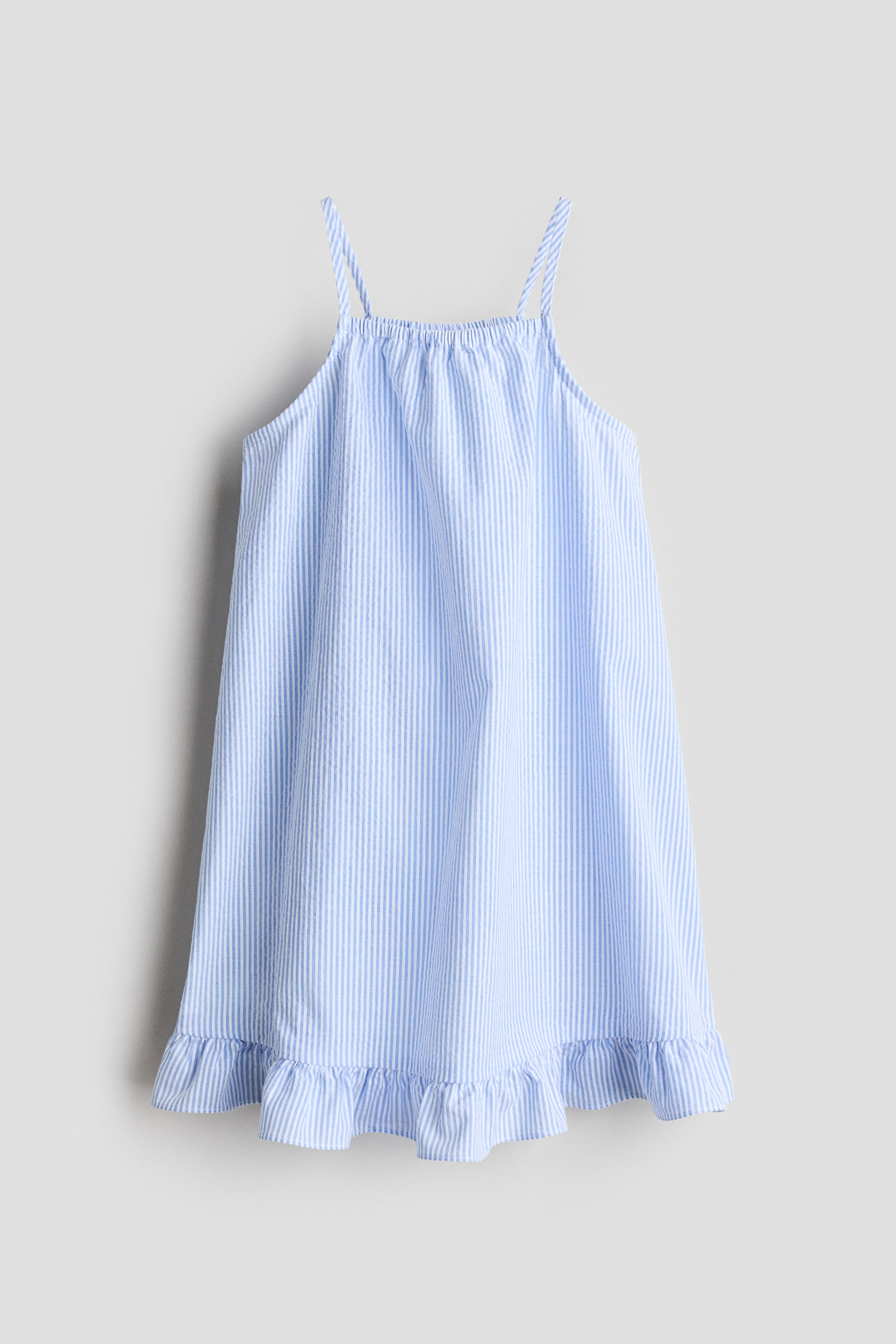 Größeres Bild anzeigen: Ein Kleid präsentiert sich in einer FRONT-Ansicht, mit vertikalen blauen und weißen Streifen auf einem strukturierten Stoff. Es ist mit dünnen Spaghettiträgern, einem gerafften geraden Ausschnitt und einem breiten Rüschenabschluss am Saum gestaltet.