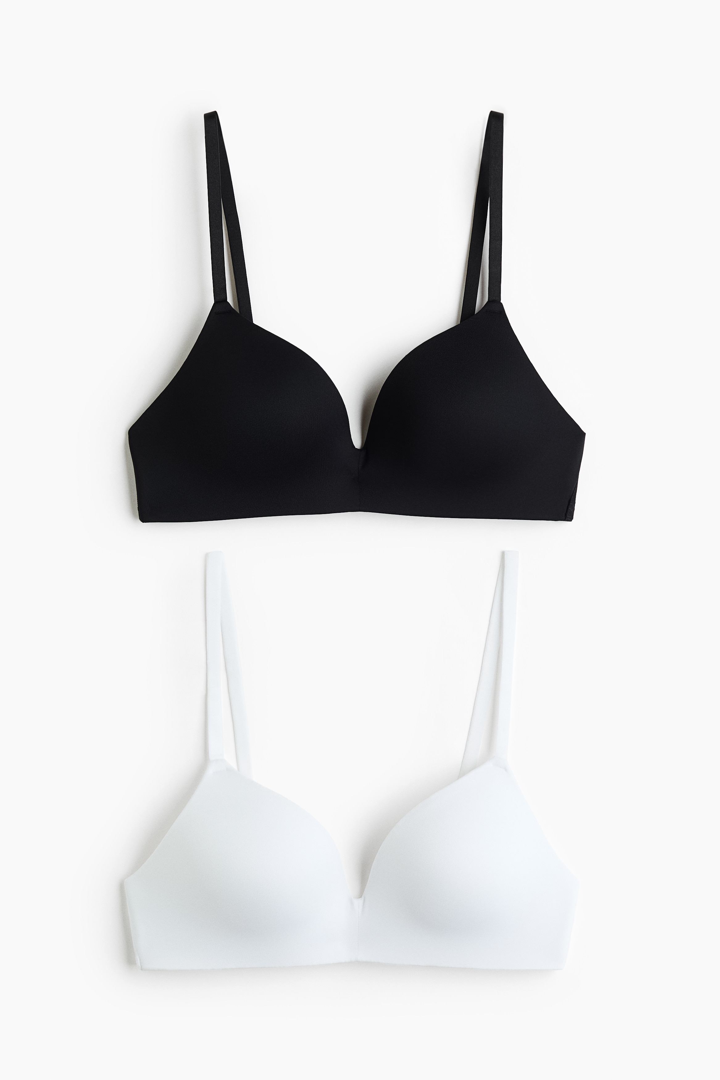 The model is donning a white microfiber bra featuring padded cups and adjustable shoulder straps, paired with matching white underwear bottoms.