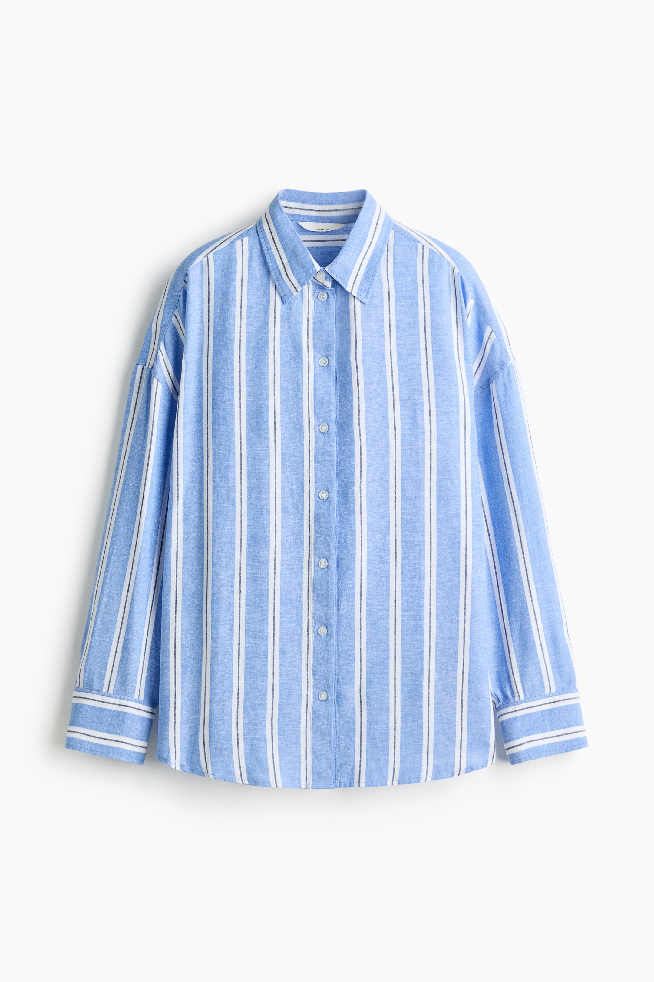 View larger image: A blue and white striped shirt is shown from the front, featuring a pointed collar, a full button placket with light-coloured buttons, long sleeves, and buttoned cuffs. Vertical stripes run down the shirt in alternating blue and white bands, with the white bands also incorporating thin black lines.