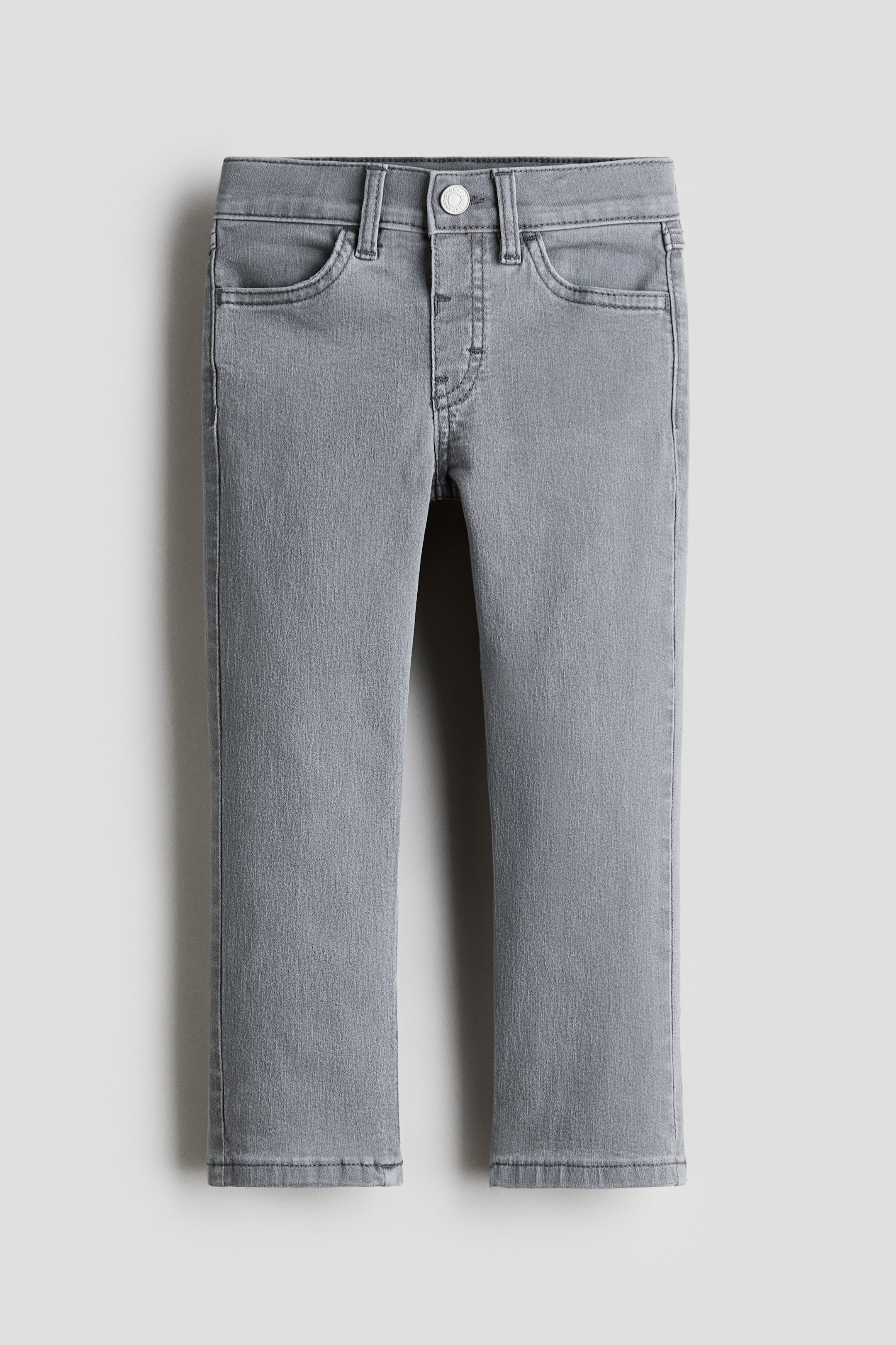 Agrandir l'image: Jean en denim gris délavé présentant une coupe ajustée vue de face. Ils sont dotés d'une fermeture à bouton au-dessus d'une fausse braguette, de deux poches avant arrondies et de passants de ceinture le long de la taille.