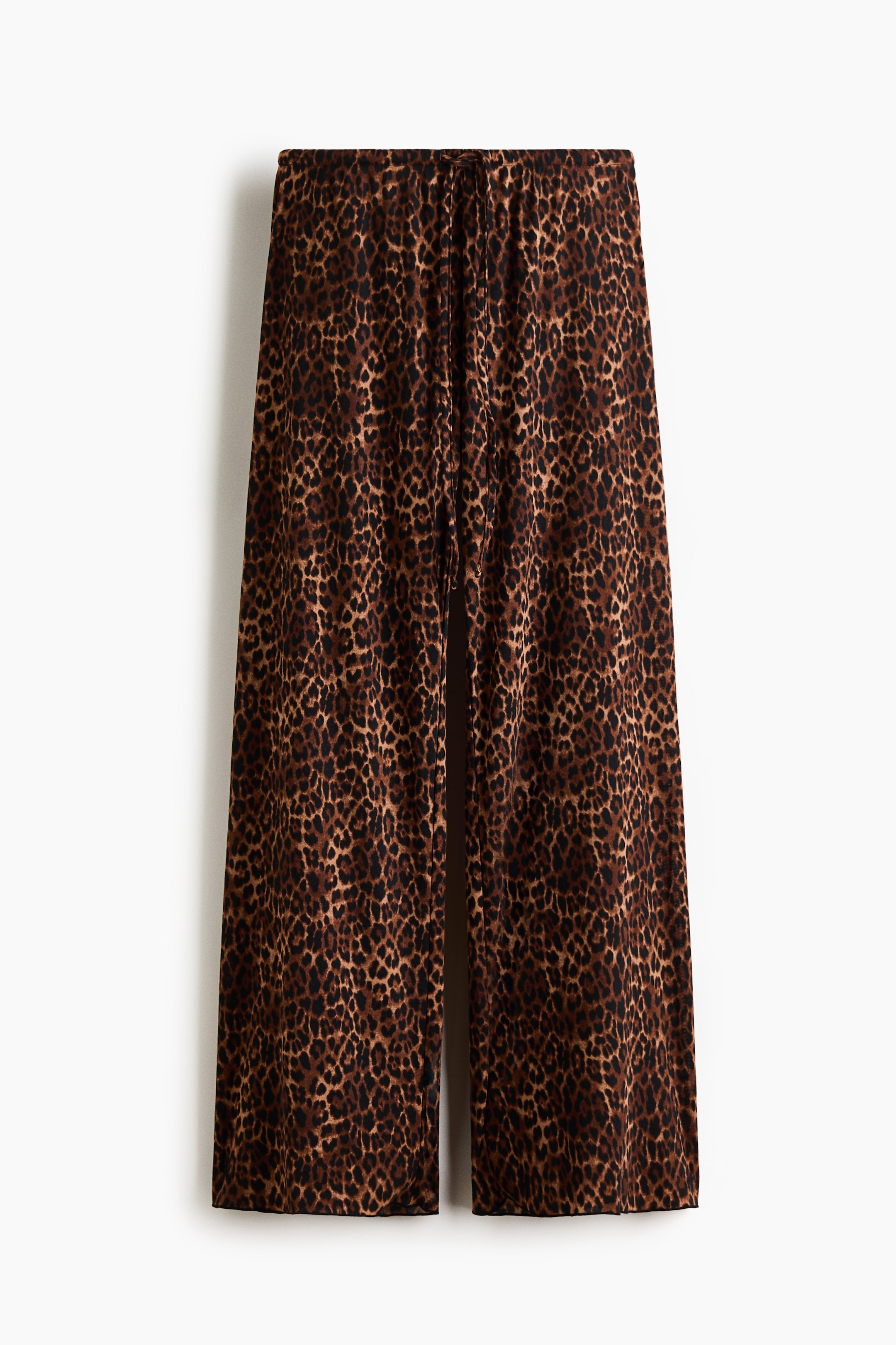 Grotere afbeelding bekijken: Loszittende pyjamabroek in zachte jersey, gepresenteerd in een vooraanzicht, met een bruin en zwart luipaardprint. Ze zijn ontworpen met een elastische tailleband met trekkoord en wijde pijpen met overlockzomen.