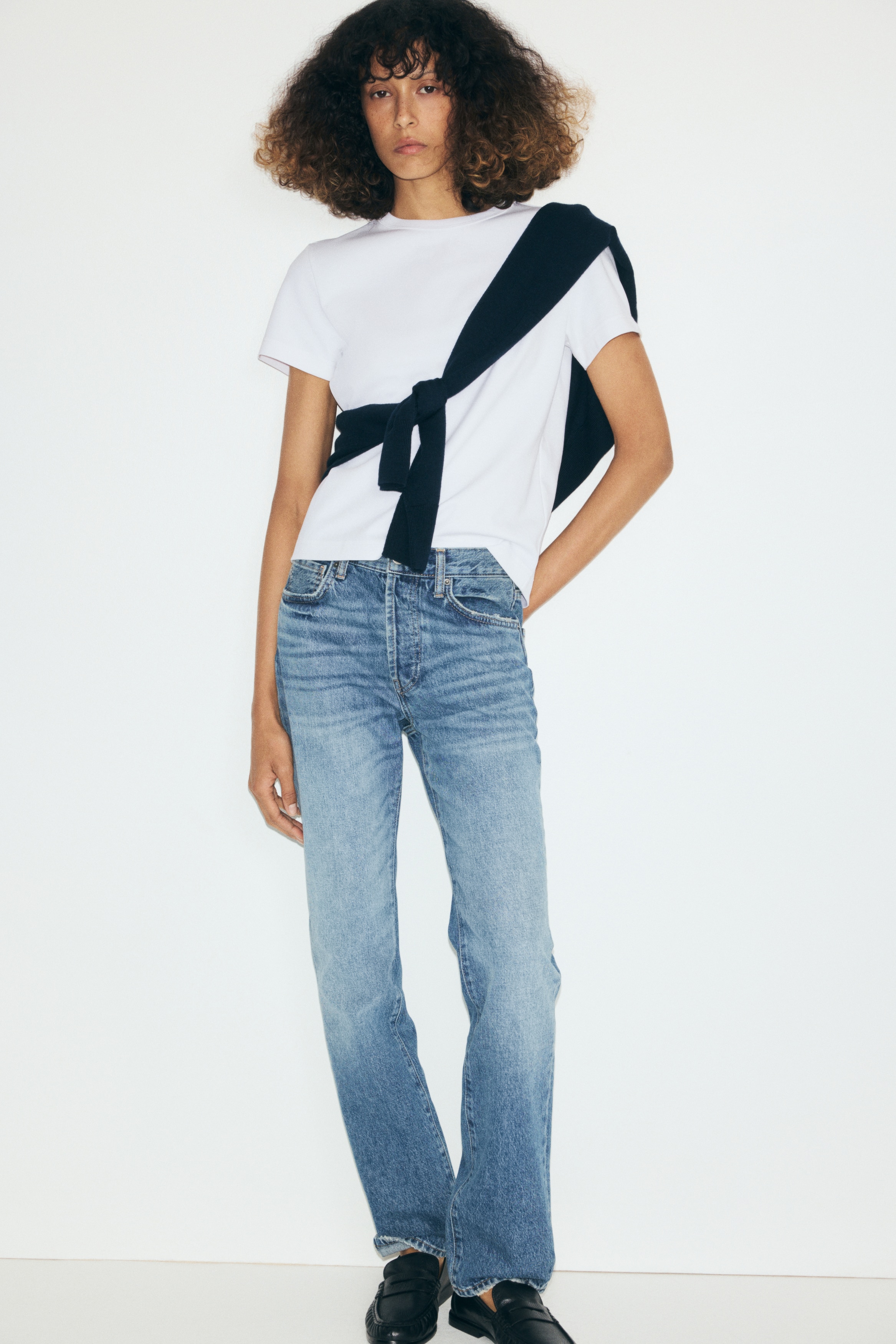 A white short-sleeved T-shirt is shown front-facing, featuring a classic ribbed crew neck, a straight hem, and a regular fit.