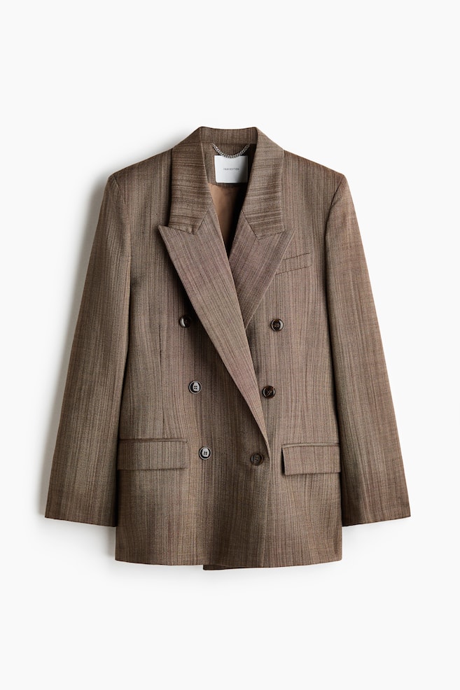 Dieser braune, zweireihige Blazer in Frontansicht verfÃ¼gt Ã¼ber breite fallende Revers, strukturierte Schultern und einen Sechs-Knopf-Verschluss. Der Blazer zeigt ein dezentes, strukturiertes vertikales Muster, zwei aufgesetzte Pattentaschen unten sowie eine Brustleistentasche auf der linken Brustseite. - 1
