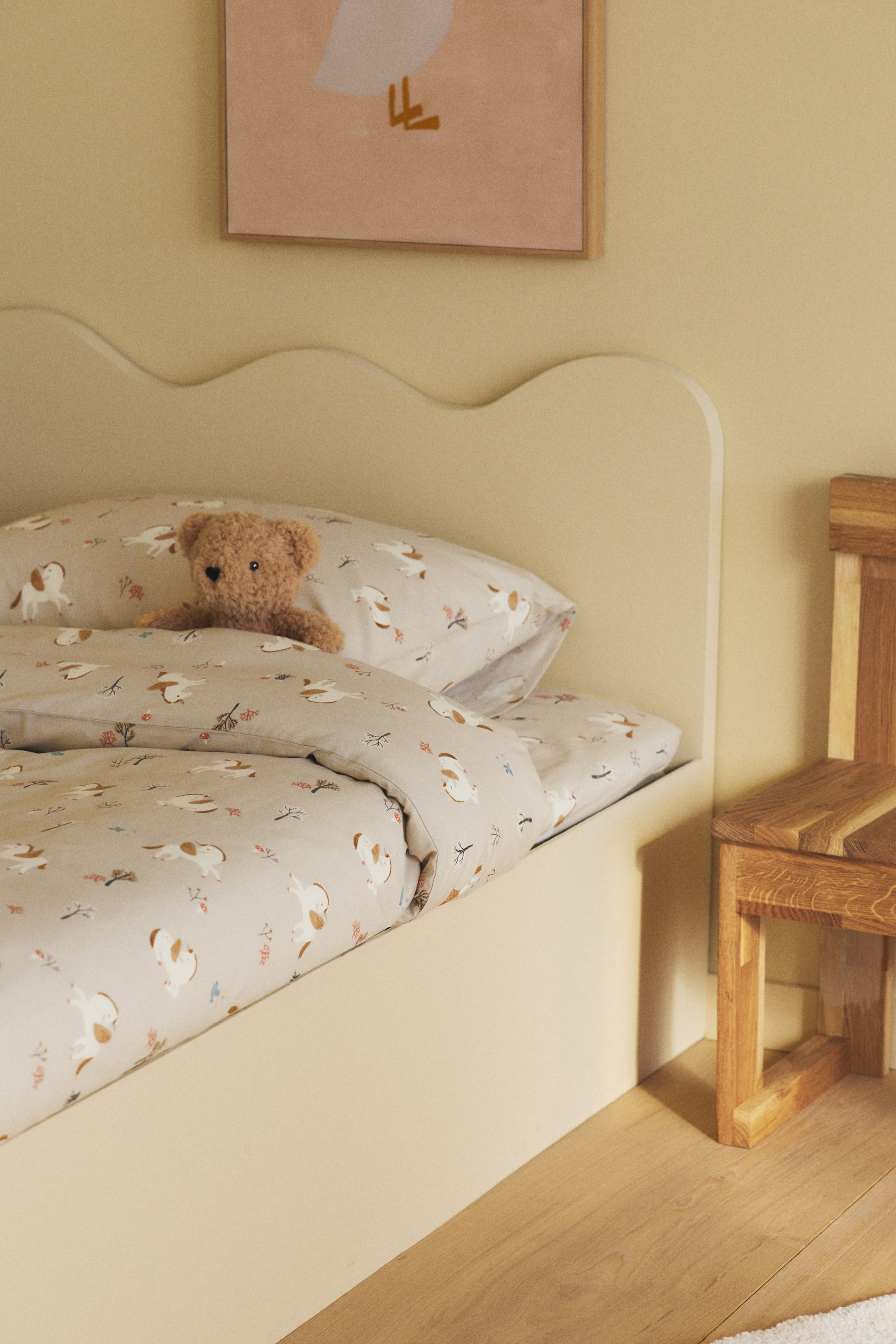 Voir une image plus grande: Ensemble de housse de couette simple mettant en valeur un tissage en coton à motifs, avec un design répétitif d'animaux blancs et bruns et de petits éléments botaniques sur un fond clair. La housse de couette apparaît pliée sur un lit avec une ouverture en bas, et une taie d'oreiller assortie est placée dessus, dotée d'une ouverture à rabat.
