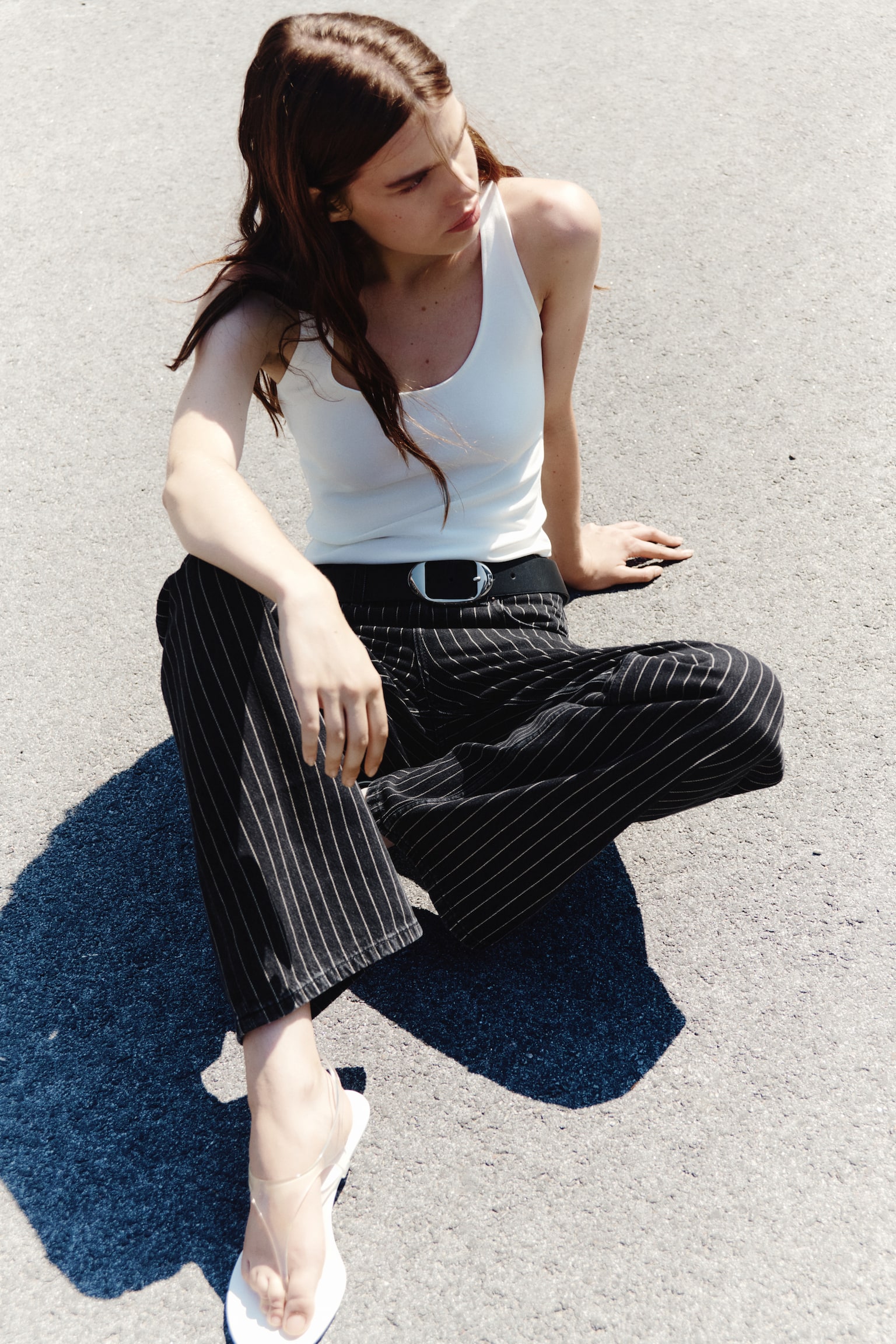 Pantalones de pierna ancha en denim negro con finas rayas verticales beige, cierre de botón, cremallera, trabillas para cinturón y bolsillos delanteros tipo scoop. - 1