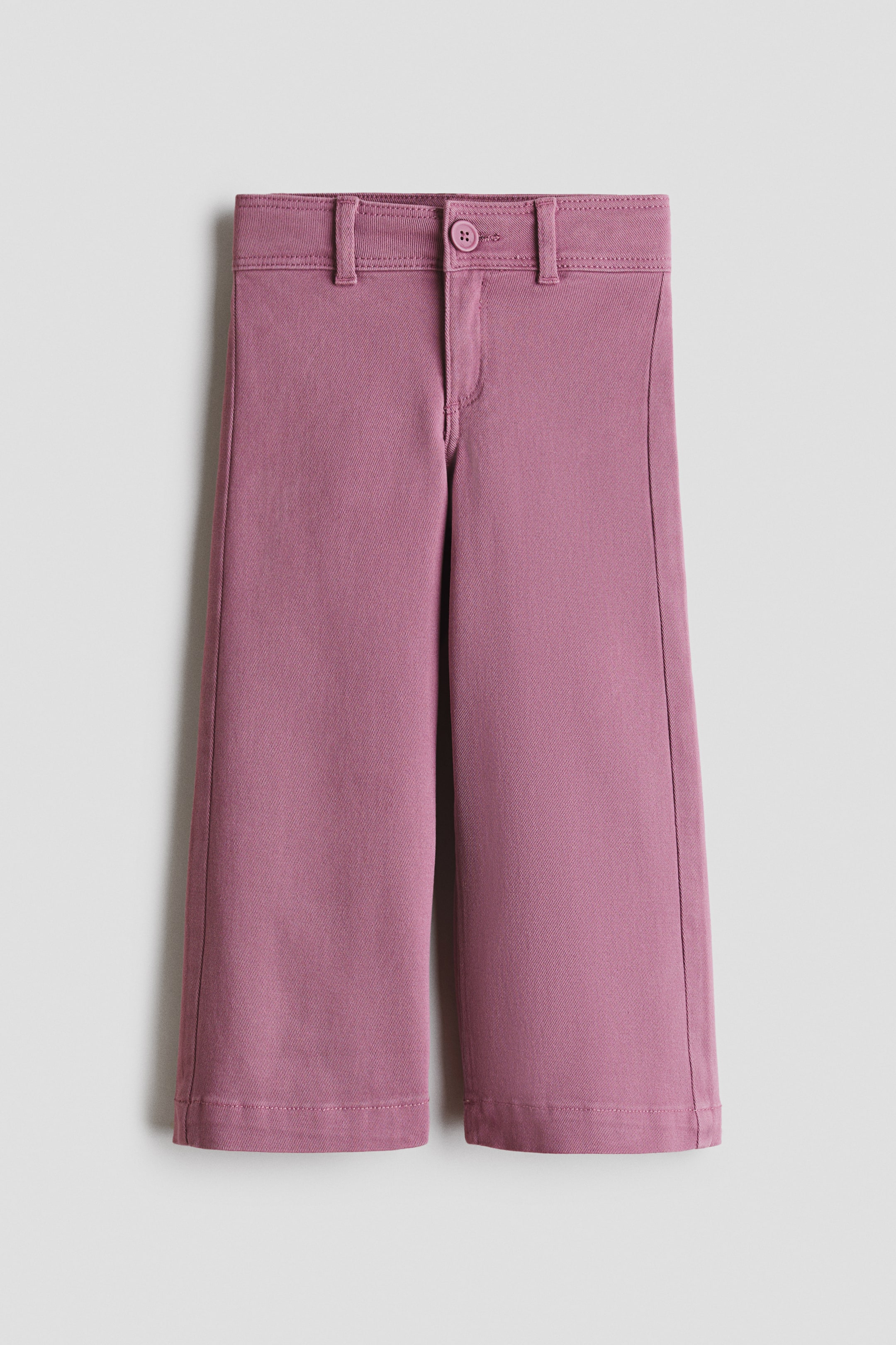 Vis større bilde: Mauve vide benbukser med cropped lengde har en synlig twill-struktur, høy linning med beltehemper, en enkelt knappe-lukking og glidelås. Vertikale sømmer går nedover forsiden av hvert ben.