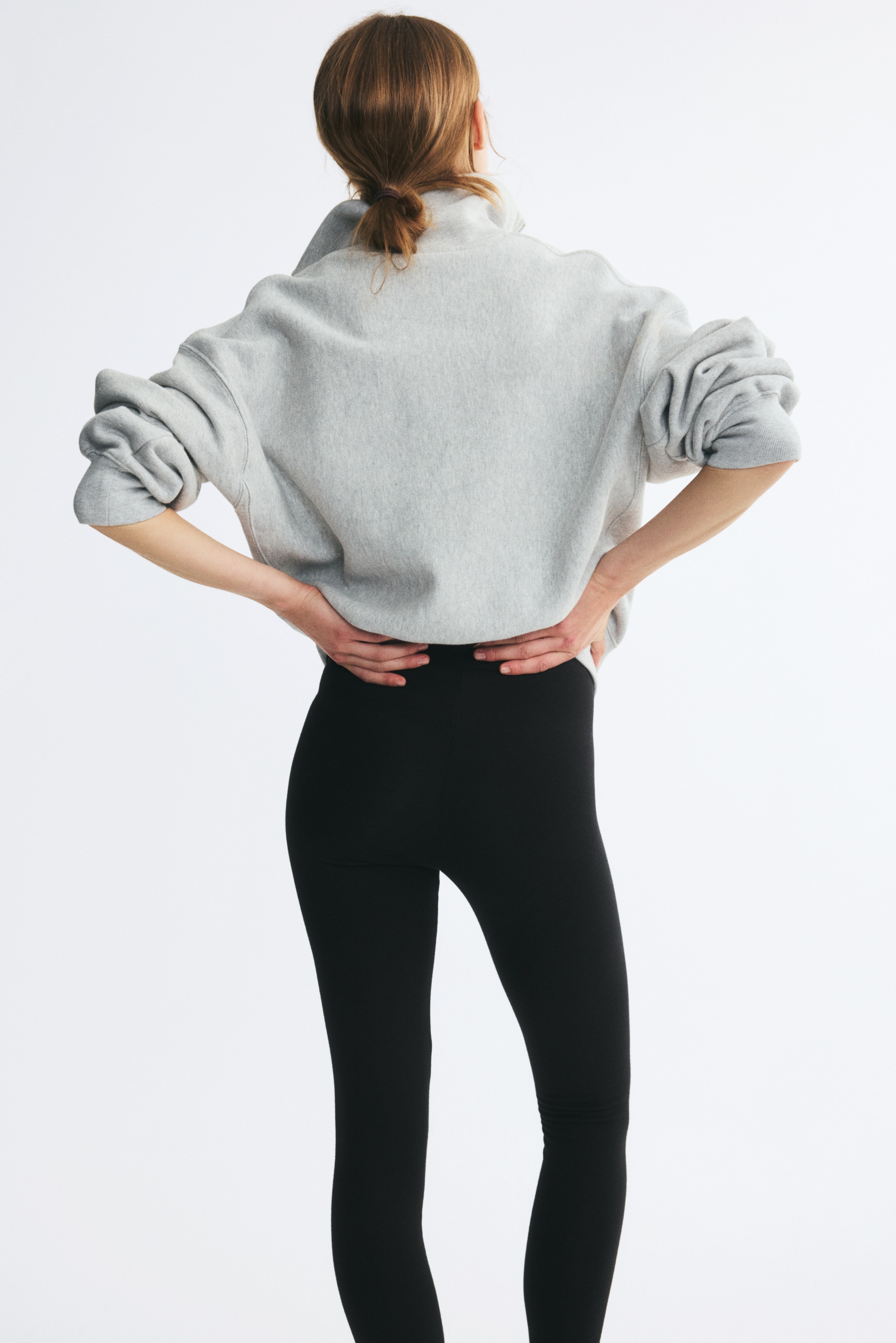 Svarta leggings presenteras platt, med ett brett, platt midjeband och avsmalnande, ankellånga ben. Framsidan framhäver deras åtsittande design.