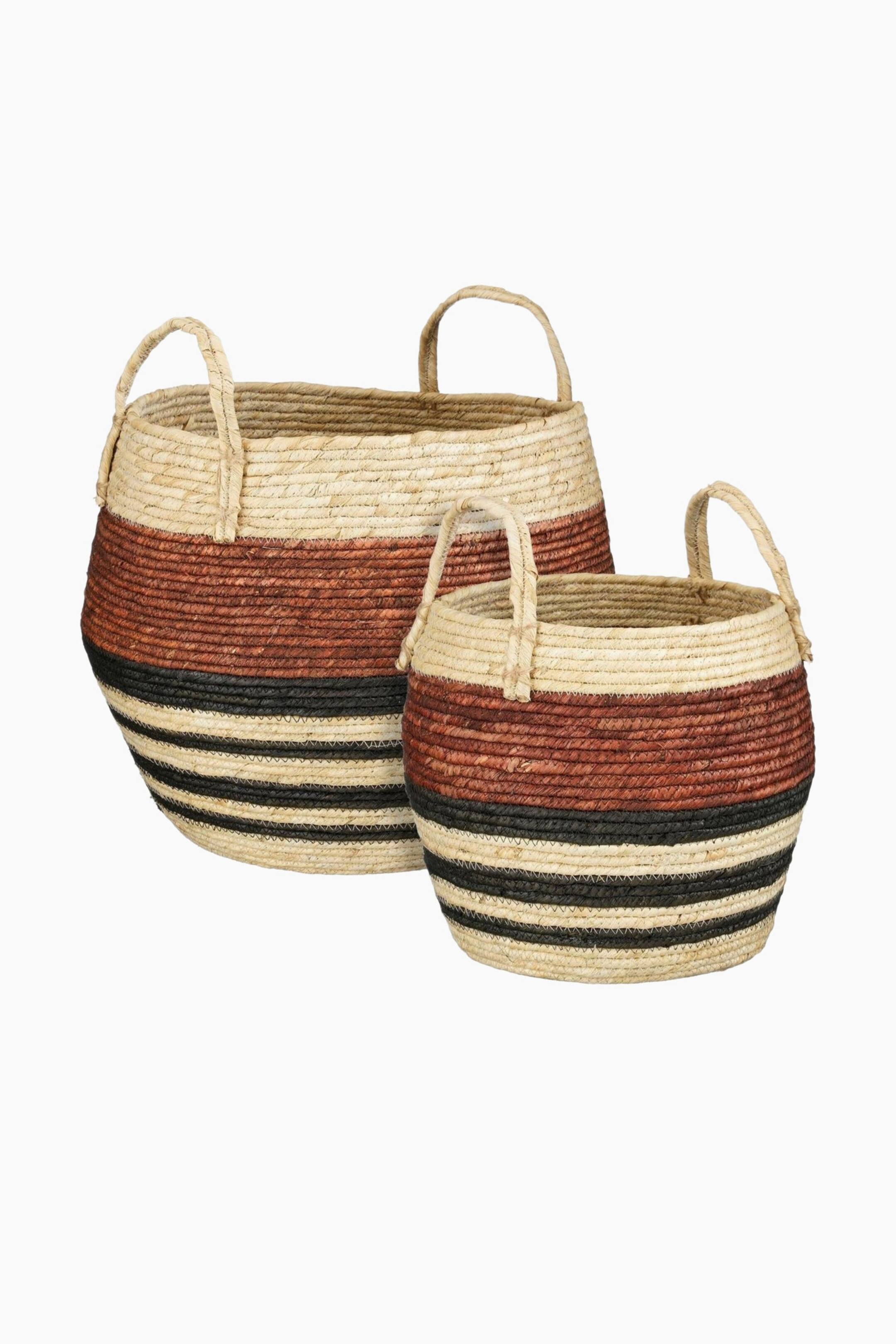Agrandir l'image: Un ensemble de deux paniers ronds tressés présente un matériau beige naturel avec une large bande brun-rouge et plusieurs rayures noires entourant leurs côtés. Chaque panier est doté de deux poignées tressées.