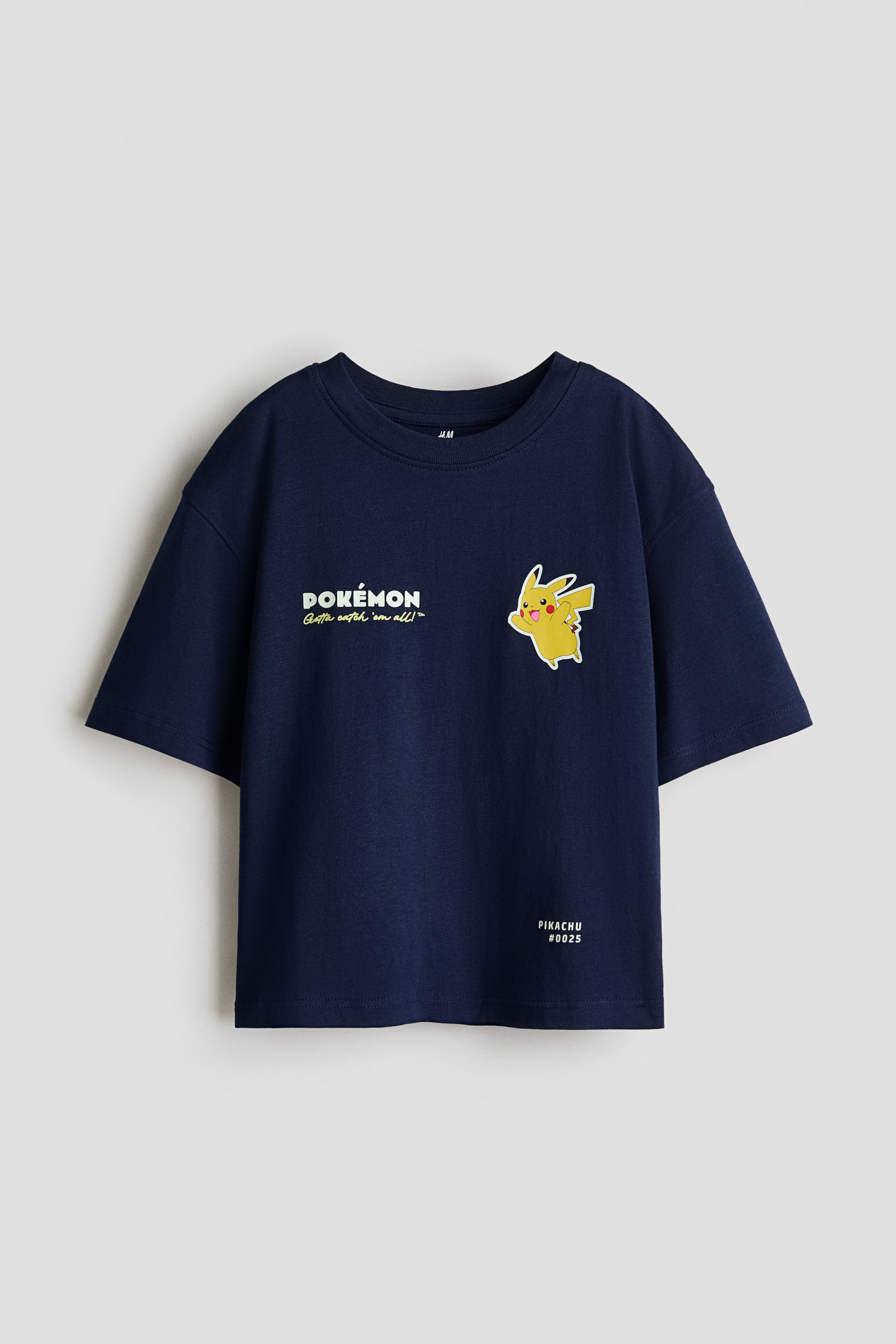 View larger image: On its front, white "POK�MON" text with yellow "Gotta catch 'em all!" is printed on the left chest, and a yellow Pikachu graphic, facing right with its arm raised, is printed on the right chest. 