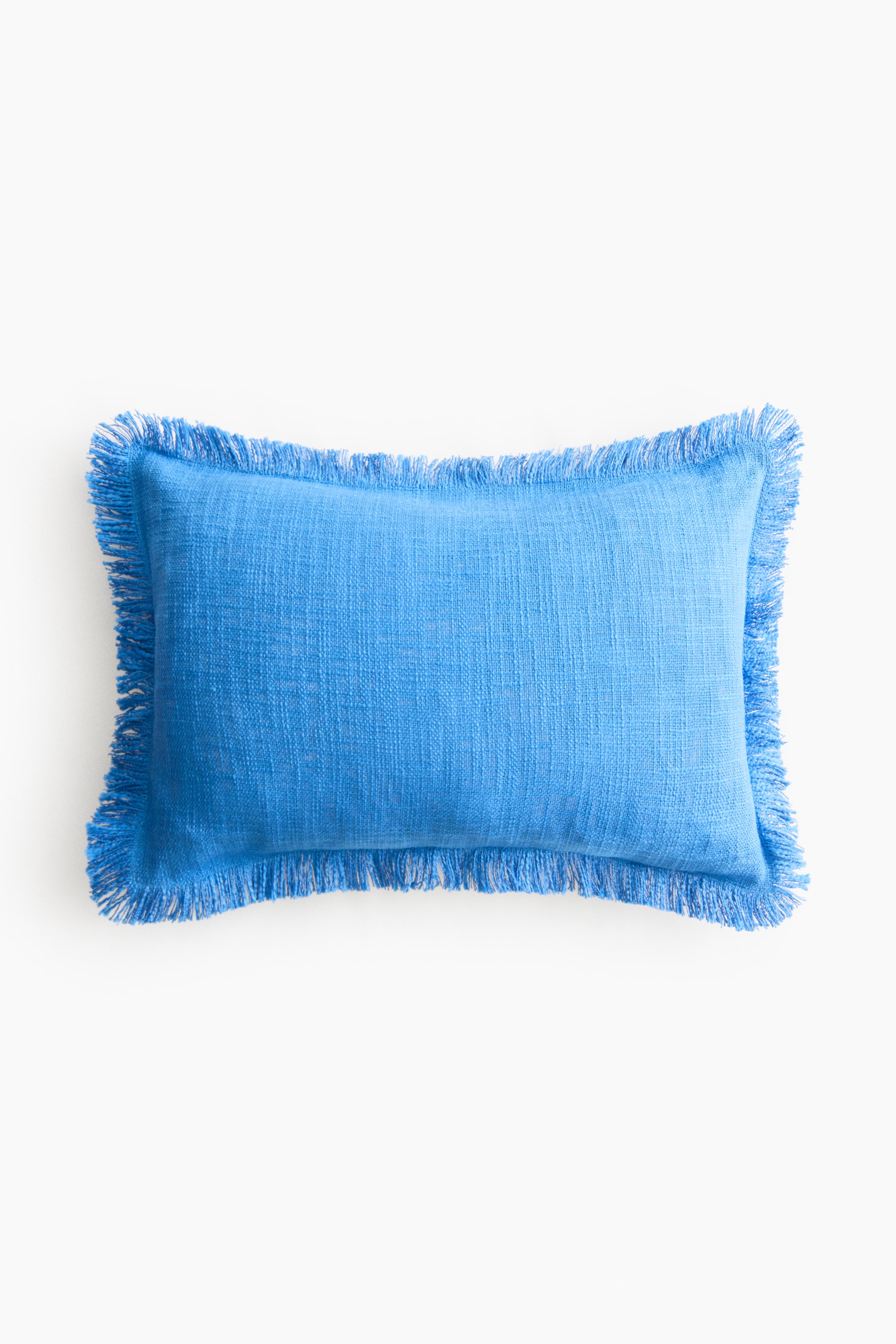 Voir une image plus grande: Un couvre-coussin rectangulaire bleu présente un tissu slub. Des franges bordent tout son pourtour et sa face avant est visible.