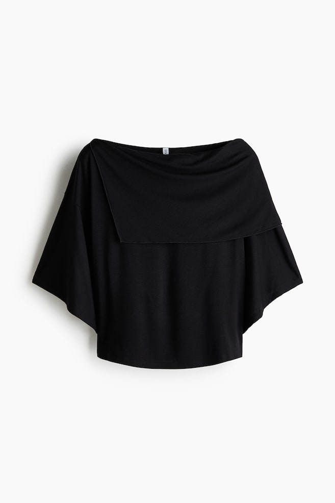 A black short top in stretch viscose jersey, shown from the front, features a boat neckline, an asymmetric cape-like layer draping across the top, dropped shoulders and short, wide sleeves. - 1