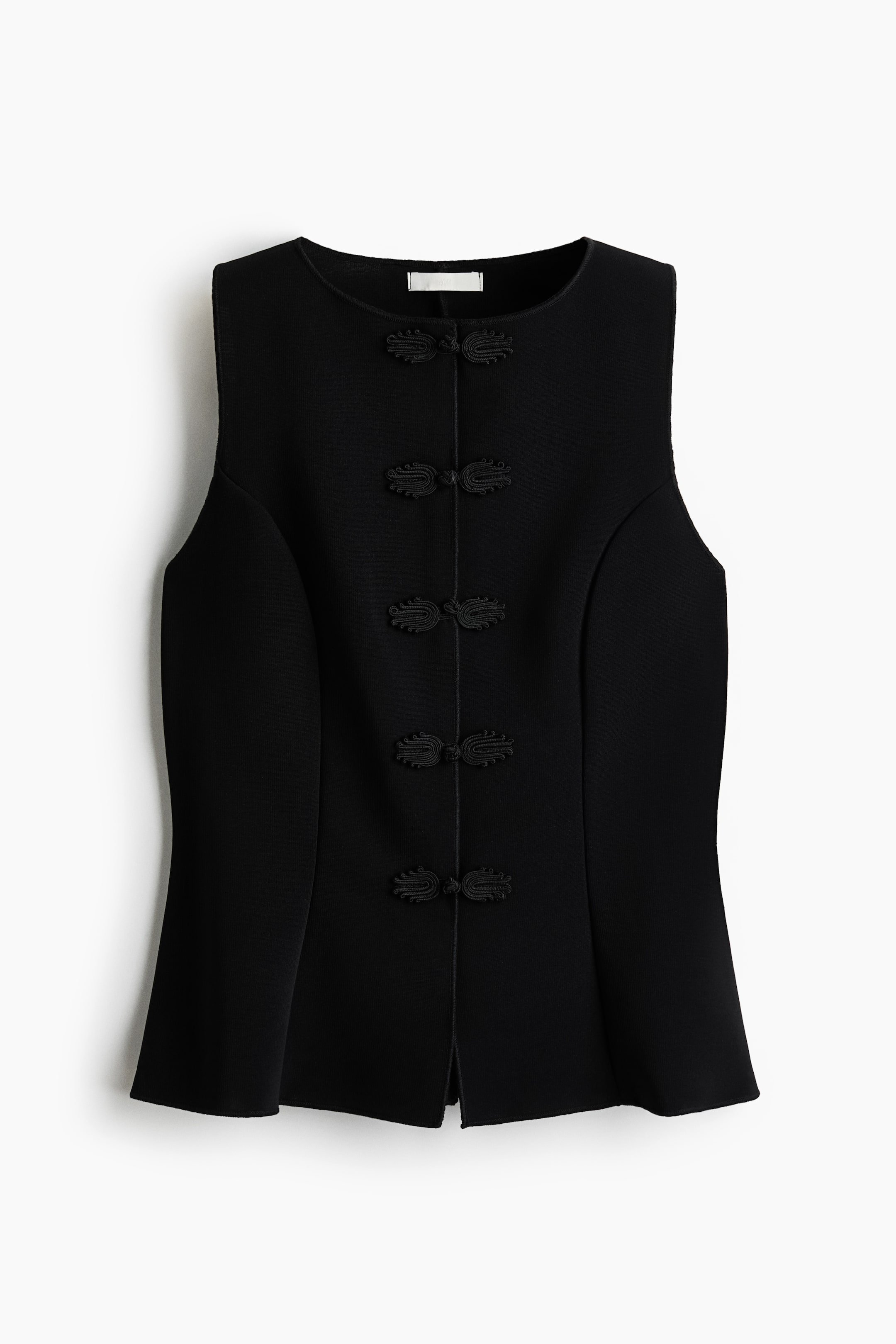 Grotere afbeelding bekijken: Een zwarte, nauwsluitende gilet van zware interlock jersey toont zijn vooraanzicht, met een ronde halslijn, vier paar knoopknopen langs het middenvoor, prinsessennaden en eindigend met een subtiel uitlopende zoom.