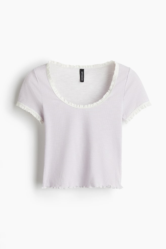 A short, fitted top is presenting as FRONT, made of a light purple and white checkered ribbed jersey. It is featuring a round, scoop neckline and short sleeves, both trimmed with white ruffled lace, and its hem is finished with an overlocked edge creating a gentle ruffle. - 1