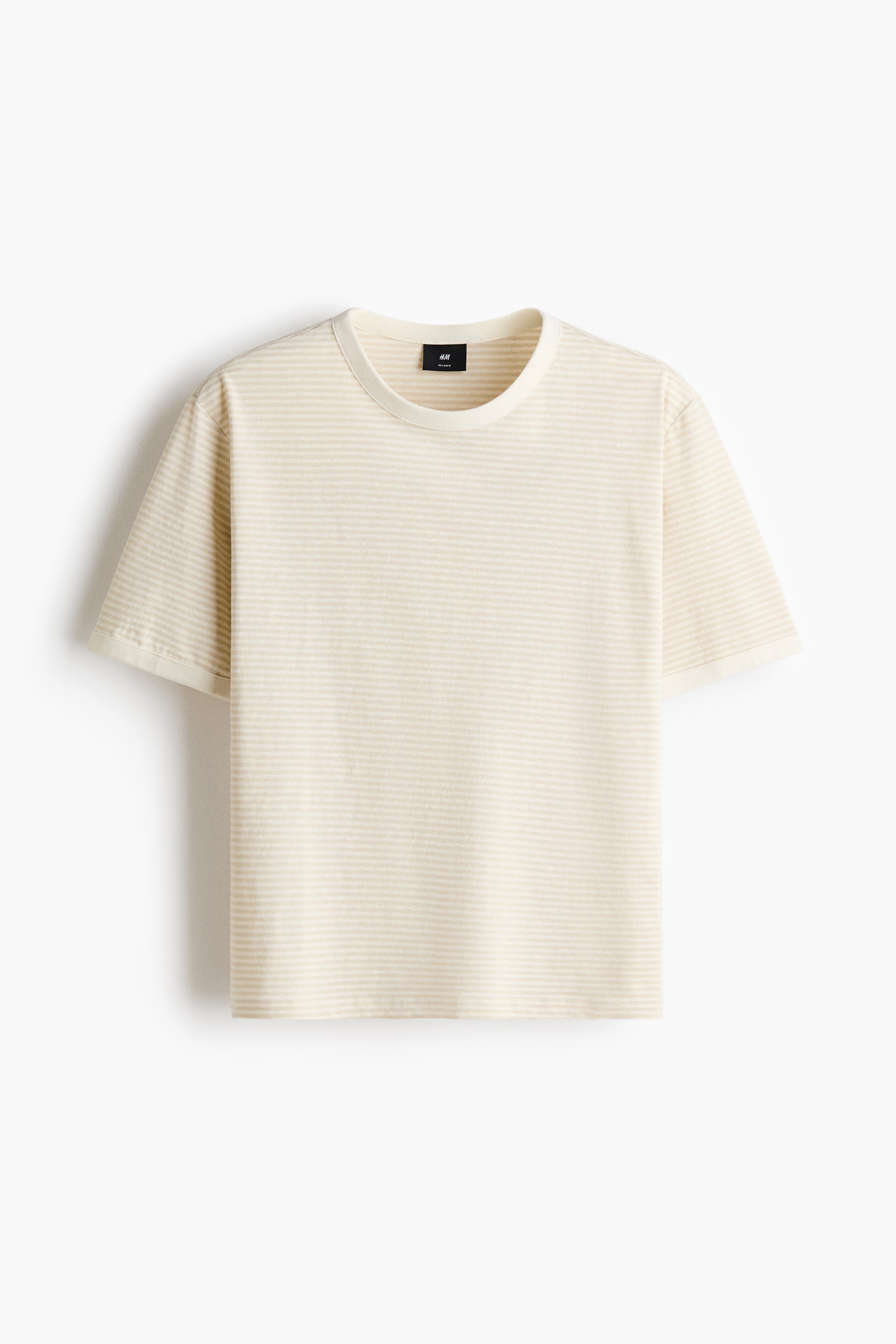 Visa större bild: En T-shirt visas framifrån och visar tunna horisontella ränder i benvitt och ljusbeige. Den är designad med en rund halsringning, nedhasade axlar, korta ärmar och en rak skuren nederkant, vilket ger en avslappnad passform.
