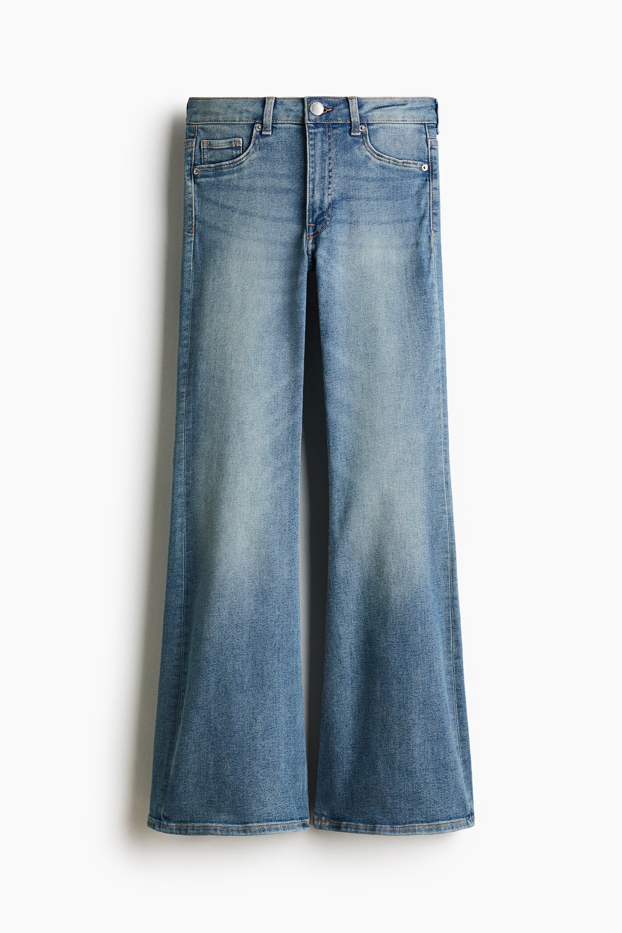 View larger image: A front view of blue denim jeans featuring a high-waisted, five-pocket design with a button closure and zip fly. The jeans have a slim fit through the waist and thighs, with a flared leg opening from the knees to the hems and light fading down the front.