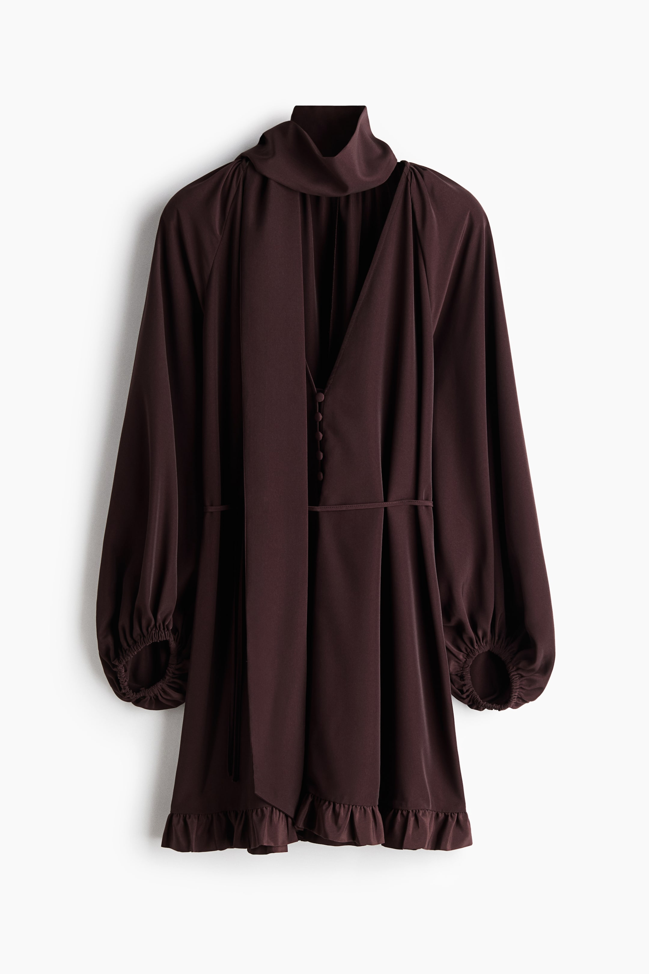 View larger image: The dark plum-brown short dress is showcased front and centre, featuring a high stand-up collar with long ties, a deep V-neckline adorned with fabric-covered buttons, voluminous long sleeves gathered at elasticated cuffs, a thin drawstring cinching the waist, and a ruffled trim detailing the short hemline.