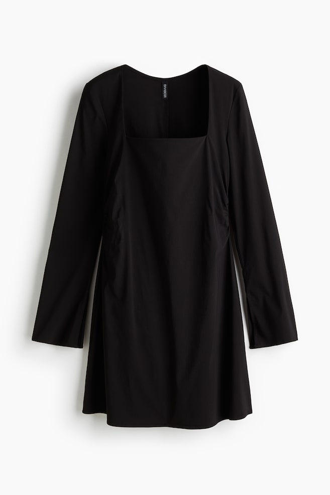 A black dress is featuring a square neckline and long sleeves. Its front is displaying a straight silhouette with subtle ruching along the sides. - 1