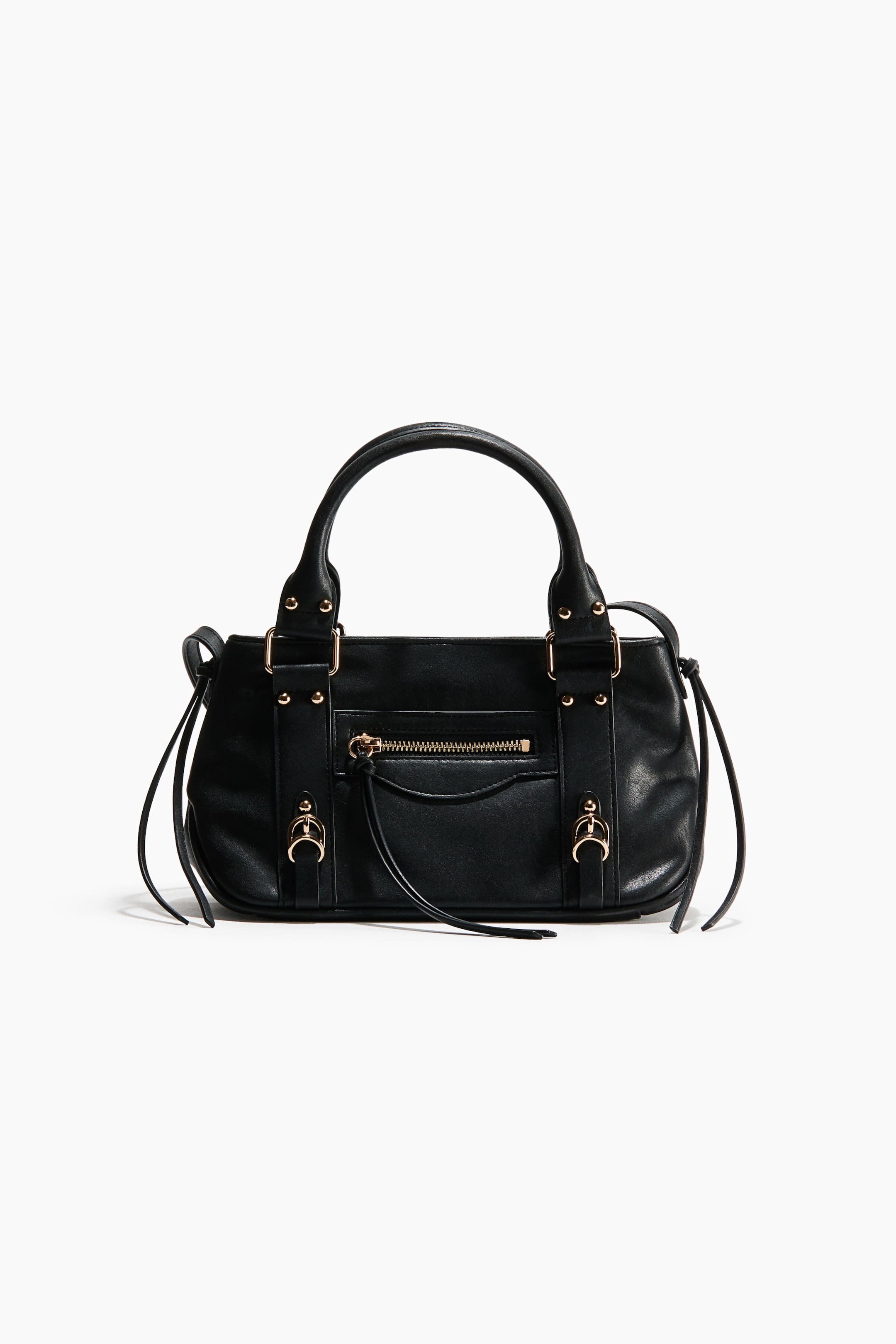 View larger image: A black crossbody bag is shown from the front, featuring tubular top handles and gold-tone metal details throughout its design. It features a small zippered outer compartment on the front with a long pull, and long knotted ties accenting each side and the front zip.