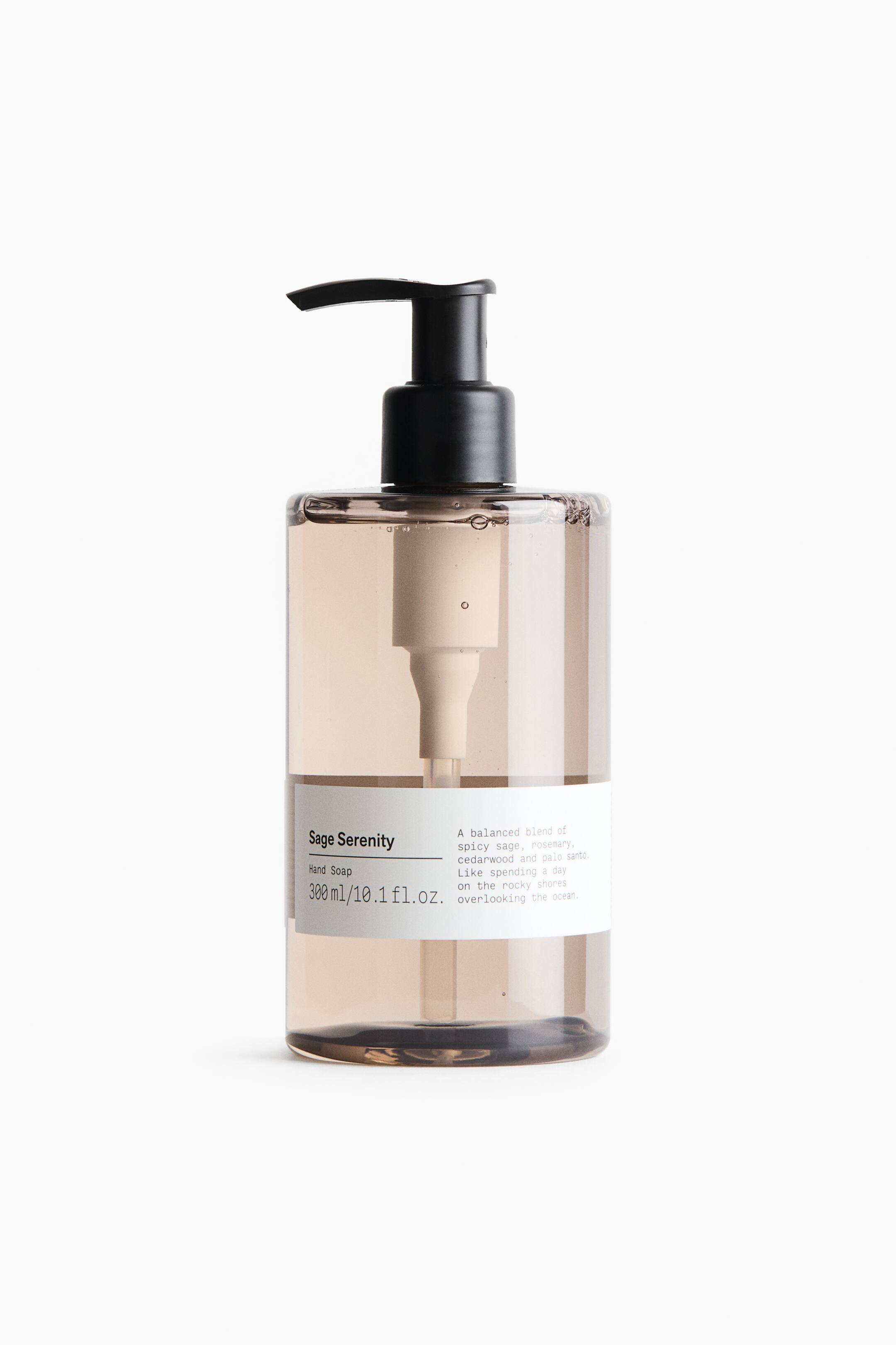 View larger image: A cylindrical, translucent brown bottle of Sage Serenity hand soap stands upright, facing forward. It features a black pump dispenser on top and displays a clean white label with black text on the lower portion.