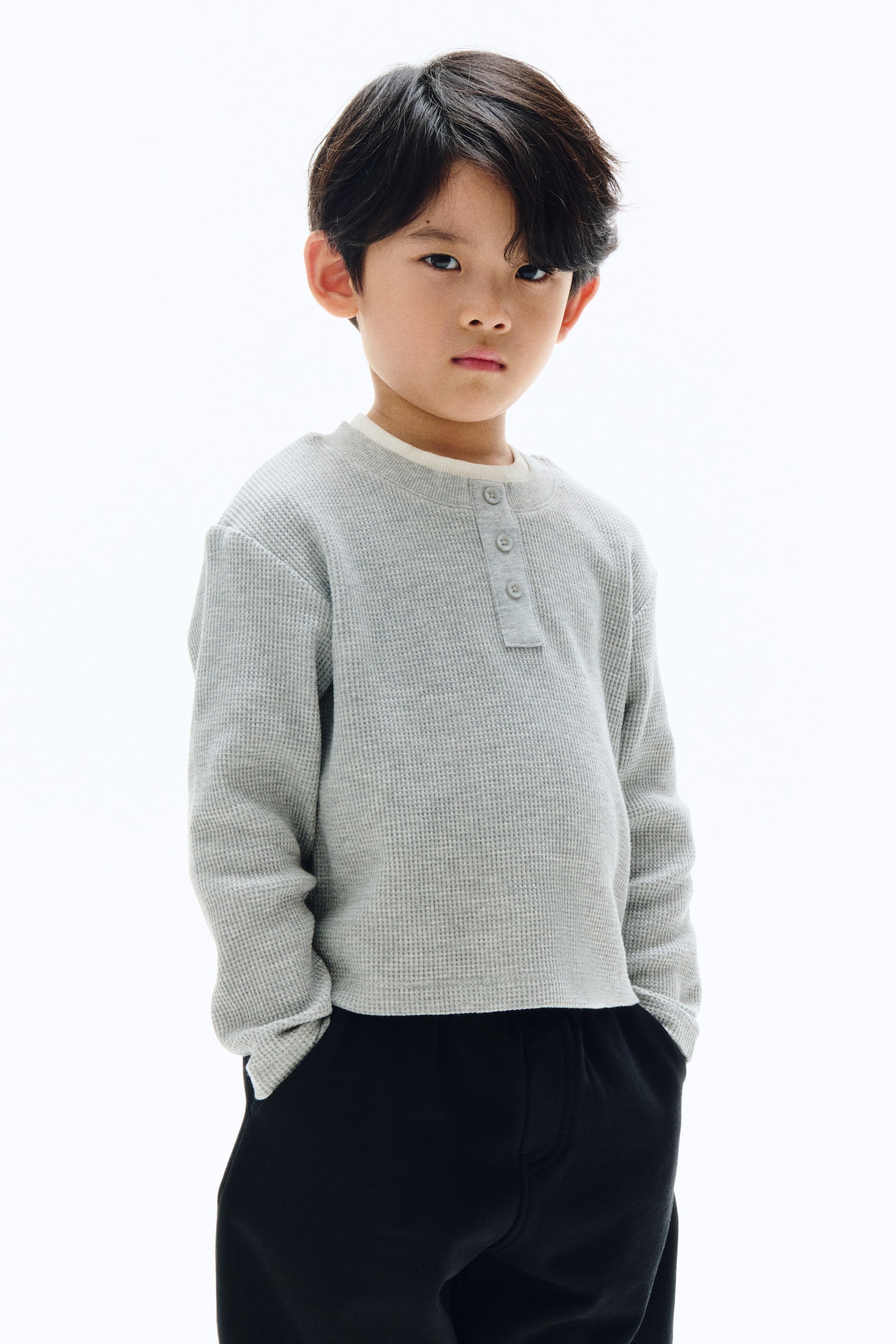 View larger image: A light gray waffle-knit long-sleeve shirt is displaying a crew neck with a three-button henley placket, and a white undershirt collar is showing at the neckline. The shirt is featuring long sleeves and is facing forward.