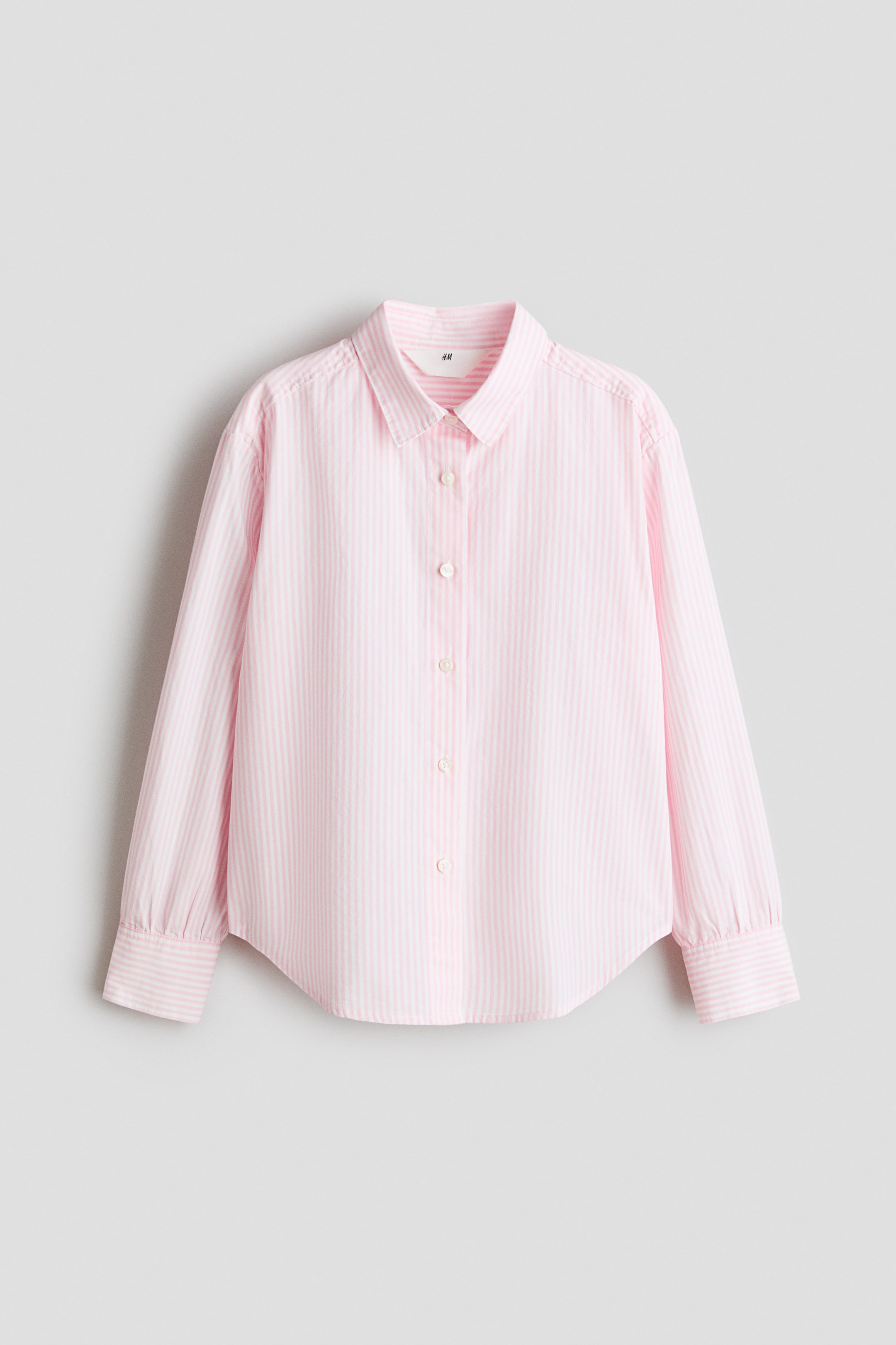 Agrandir l'image: Une chemise rayée rose et blanche se présente de face, dotée d'un col pointu, d'une fermeture boutonnée intégrale avec des boutons blanc cassé, de manches longues à poignets boutonnés et d'un ourlet arrondi.