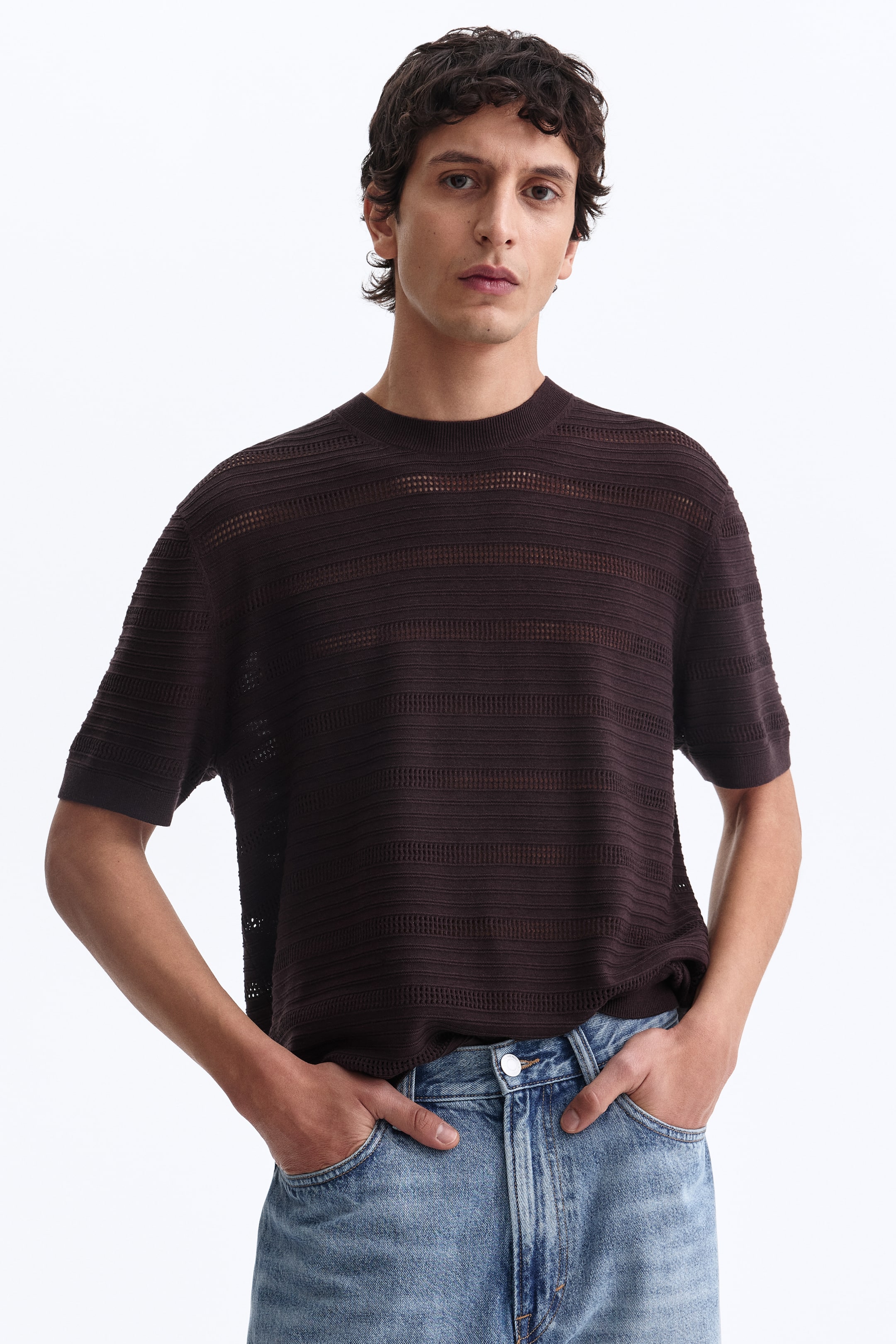 Ampliar la imagen: Un top de punto color marrón oscuro de manga corta presenta franjas horizontales alternadas de tejido opaco y calado translúcido. Está diseñado con cuello redondo acanalado y mangas cortas acanaladas, y ofrece un corte holgado.