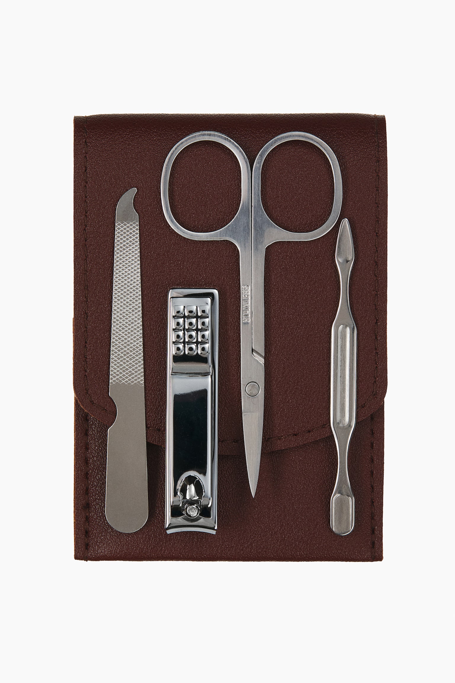 Ein Nagel-Reiseset zeigt aus frontaler Perspektive vier vertikal angeordnete Edelstahl-Pflegewerkzeuge auf einem dunkelbraunen, strukturierten Etui. Zu sehen sind eine Metall-Nagelfeile, silberfarbene Nagelknipser, Nagelhautscheren und ein doppelseitiger Nagelhautschieber.