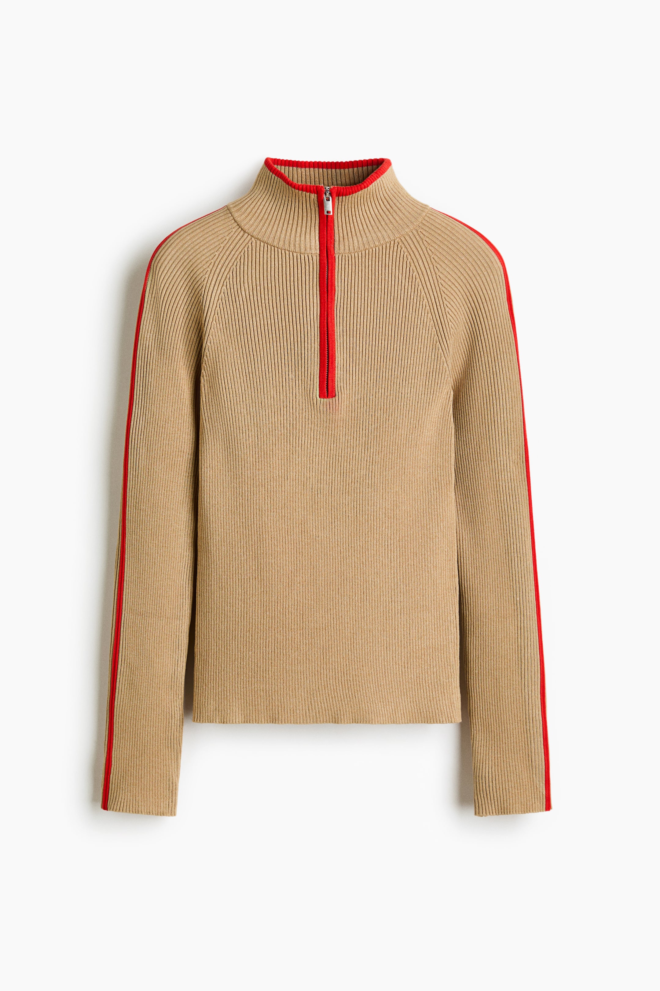 Agrandir l'image: Un haut côtelé beige avec un col montant et une fermeture éclair rouge à mi-hauteur, vu de face. Des rayures rouges descendent le long des manches raglan.