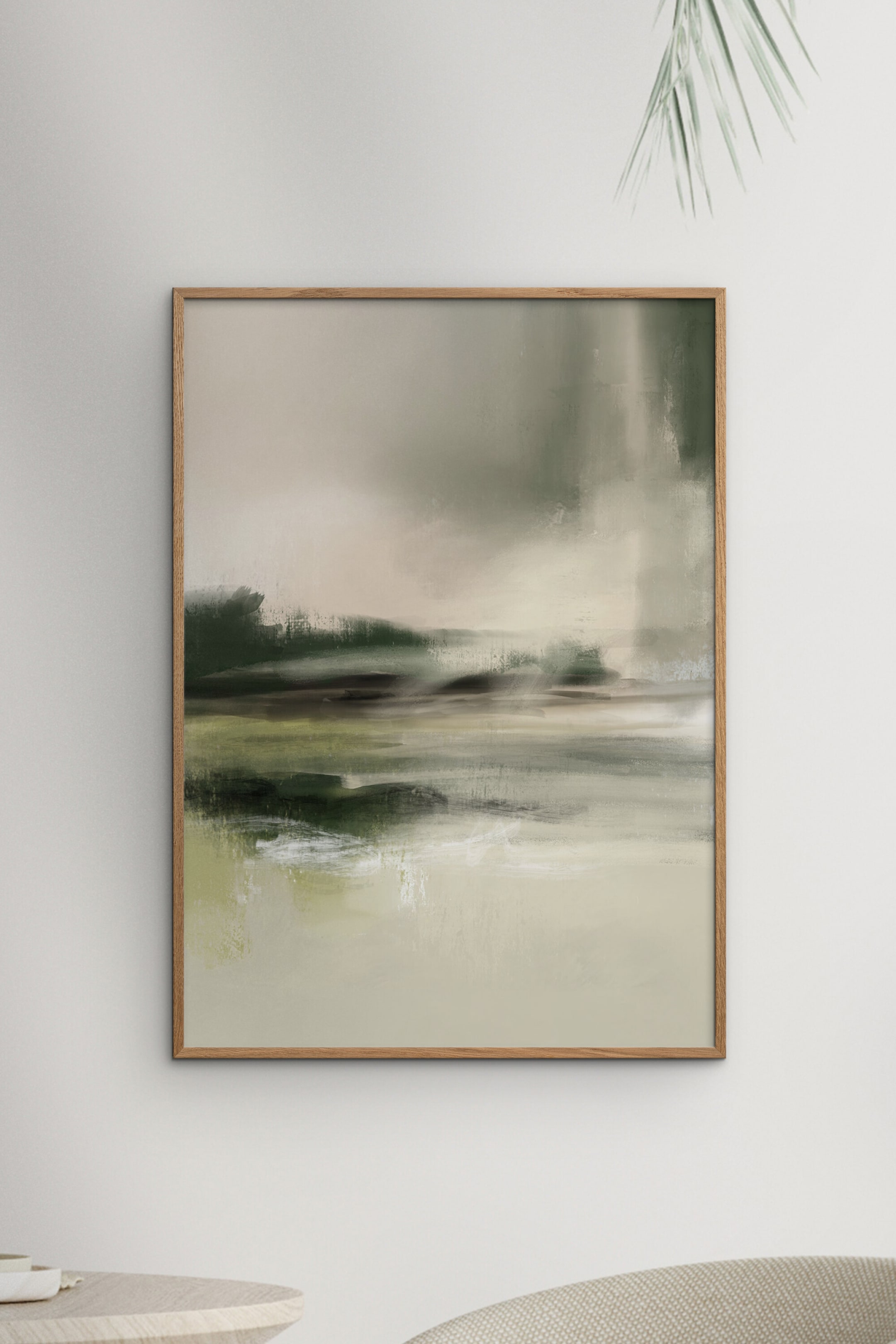 Agrandir l'image: Une peinture abstraite encadrée présente une composition paysagère de verts atténués, d'olives, de crèmes et de beiges, où de larges coups de pinceau horizontaux forment des masses terrestres plus sombres et un ciel et un premier plan plus clairs, le tout contenu dans un cadre rectangulaire en bois brun clair.