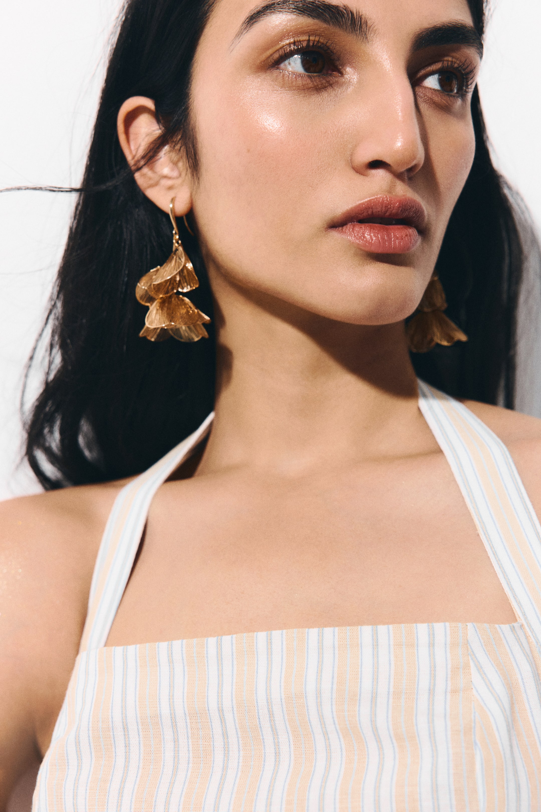 Näytä suurempi kuva: Kultasävyiset metalliset roikkuvat korvakorut, joissa on useita herkkiä, kerroksellisia kukkakuvioisia riipuksia, mallin korvissa.