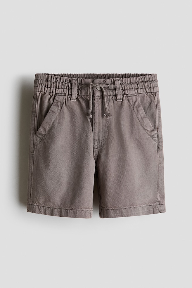 Knielange, locker sitzende Shorts aus taupefarbenem Twillstoff, die von vorne präsentiert werden, mit einem elastischen Kordelzugbund und diagonalen Vordertaschen. - 1