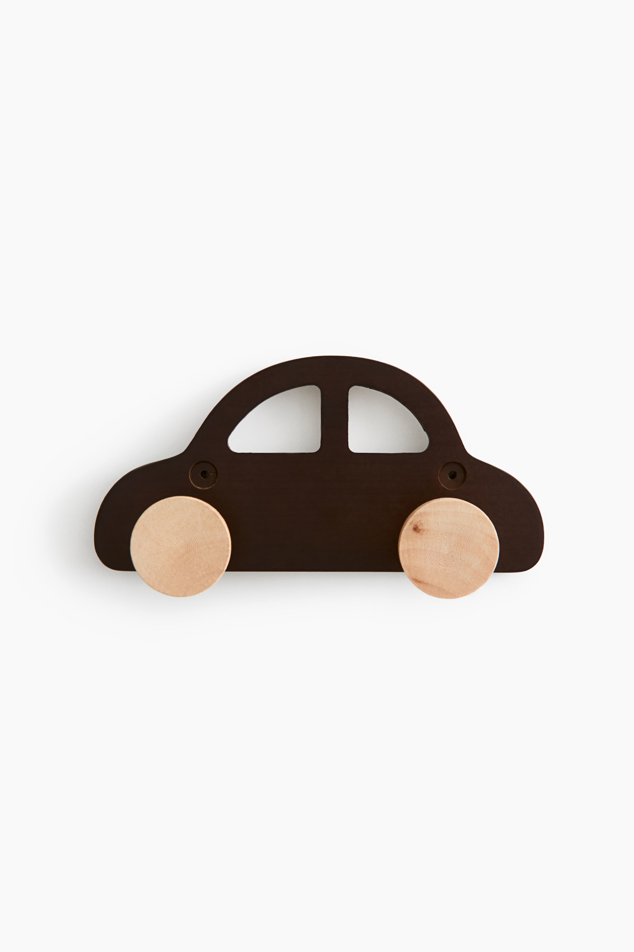 拡大画像を表示: 車の形をした木製フックラックが正面を向いており、ダークブラウンに塗装されたボディには切り抜きの窓と2つの下穴加工済みの取り付け穴が見えます。下部からは、車輪と吊り下げフックを兼ねた淡色の丸い木製ペグが2本突き出ています。