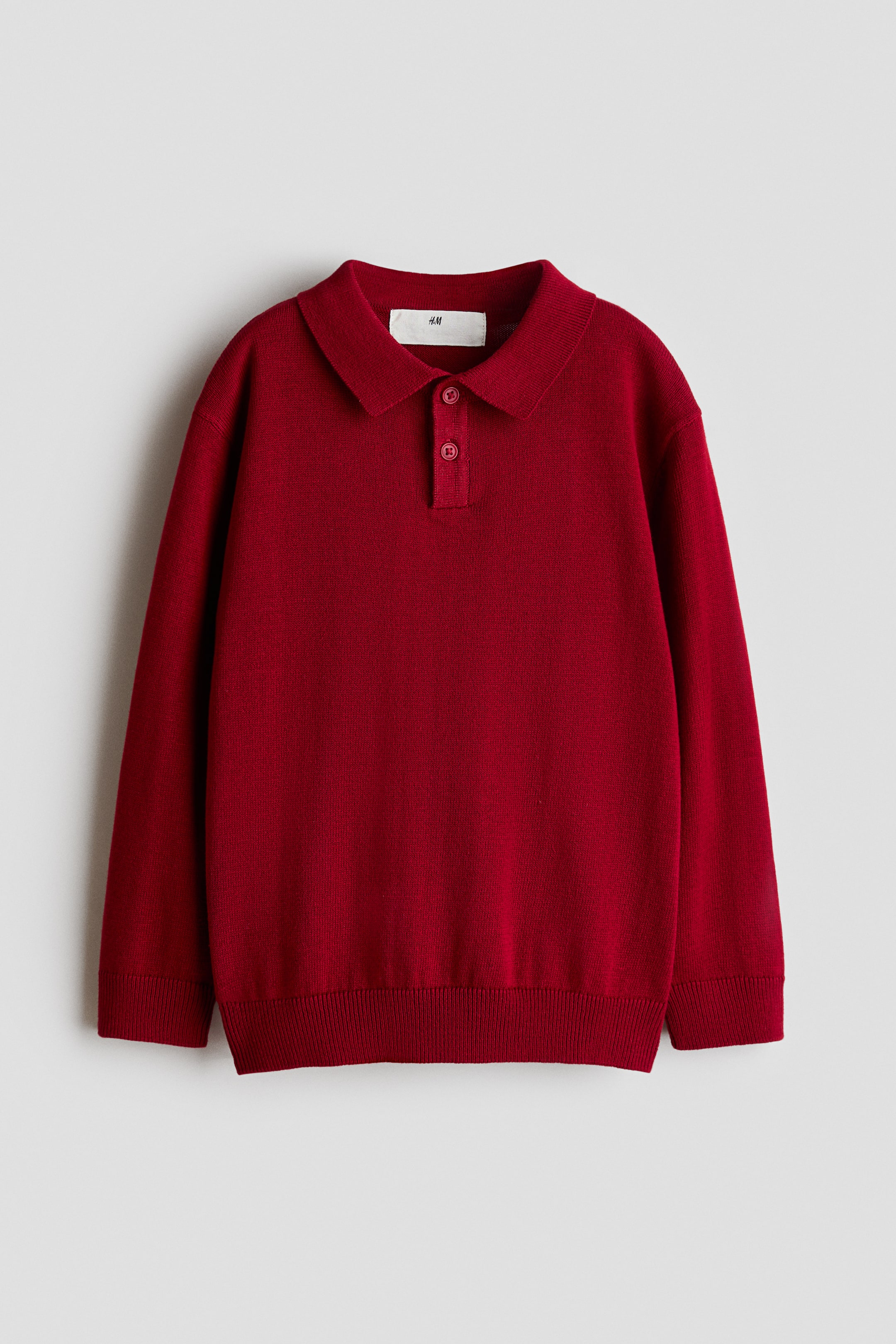 View larger image: A red long-sleeve polo sweater in fine-knit cotton is facing front, featuring a collar, a two-button placket, and ribbing at the cuffs and hem.