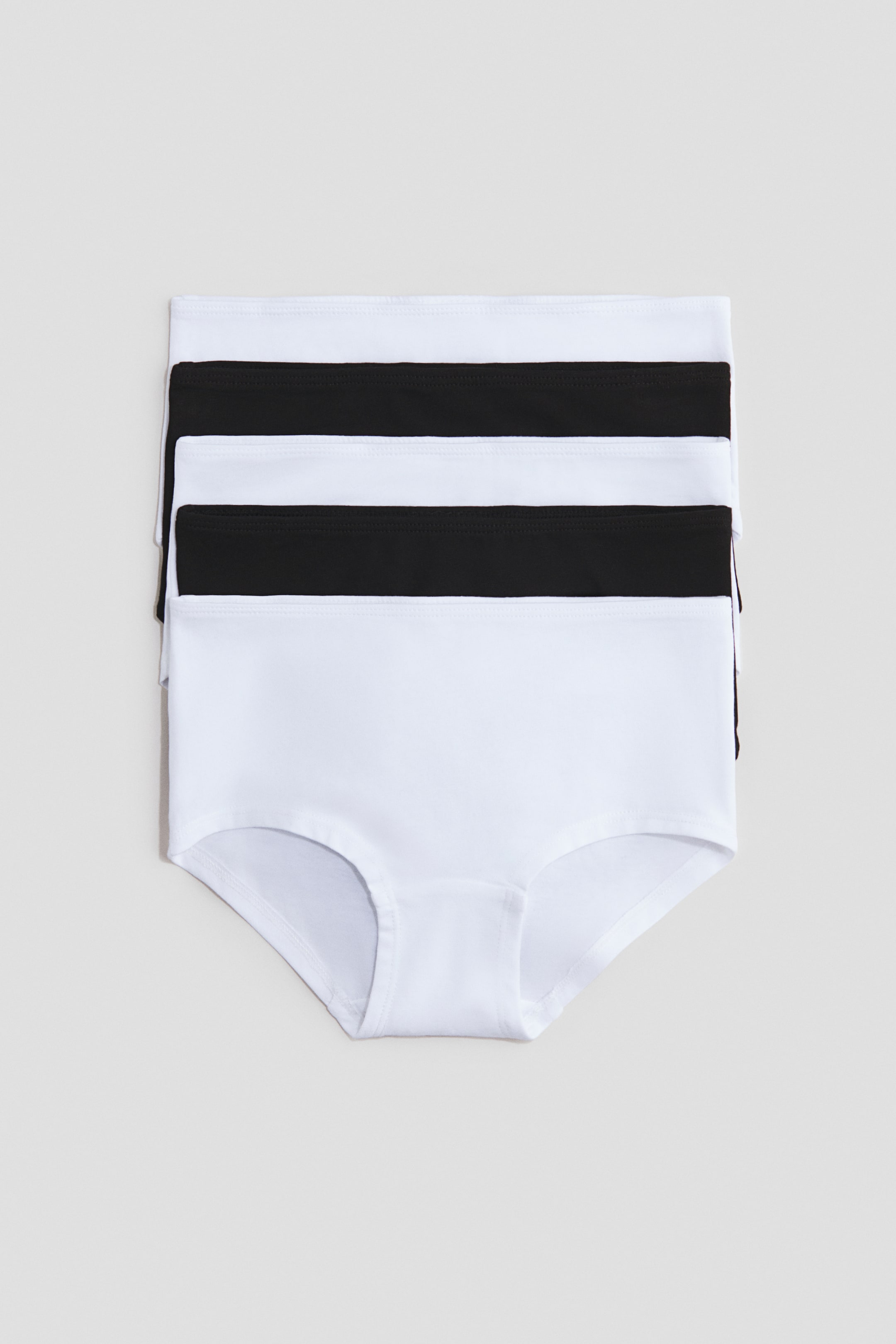 View larger image: Three pairs of high-waisted briefs are stacked, alternating in white and black, shown from the front and highlighting their smooth fabric and full-coverage design.