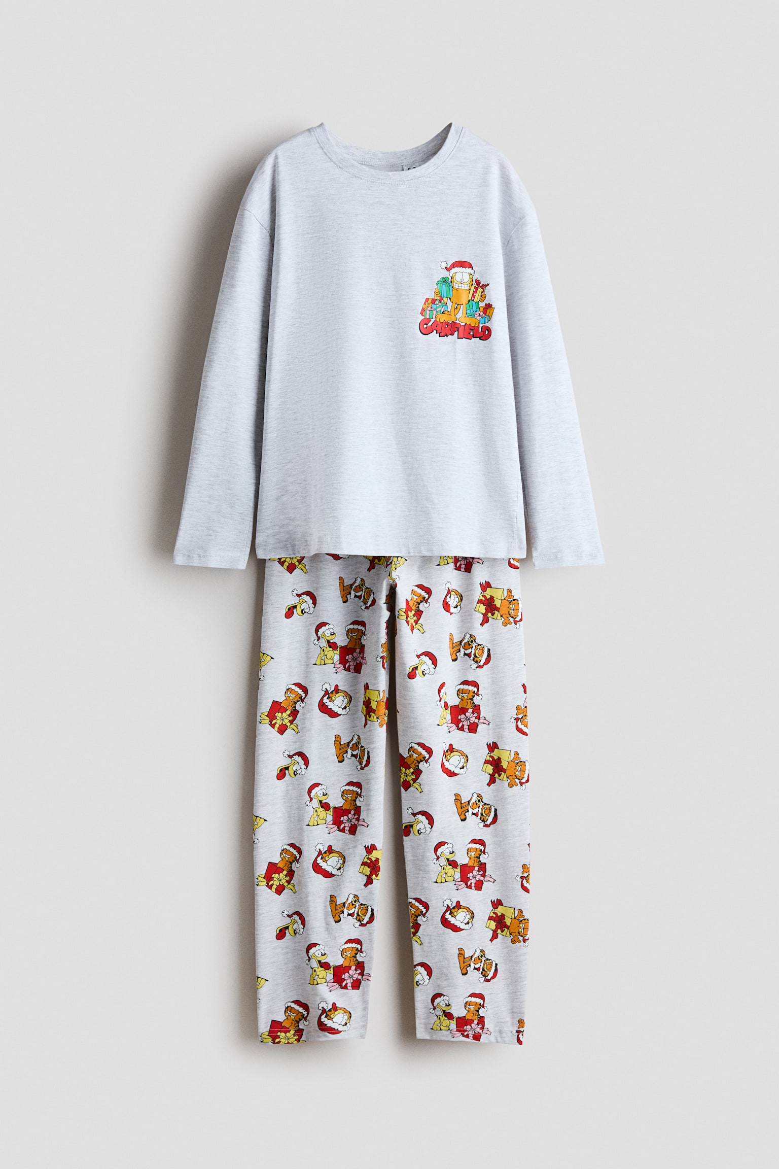 Uzun kollu bir tiÅÃ¶rt ve uyumlu pantolondan oluÅan aÃ§Ä±k gri bir pijama takÄ±mÄ±nÄ±n Ã¶nden gÃ¶rÃ¼nÃ¼mÃ¼. TiÅÃ¶rtÃ¼n gÃ¶ÄÃ¼s kÄ±smÄ±nda, yÄ±lbaÅÄ± hediyeleriyle birlikte GarfieldâÄ±n kÃ¼Ã§Ã¼k bir gÃ¶rseli yer alÄ±rken, eÅleÅen pantolonda Garfield ve Odieânin yer aldÄ±ÄÄ± tÃ¼m yÃ¼zeye yayÄ±lan Åenlikli bir desen bulunuyor.