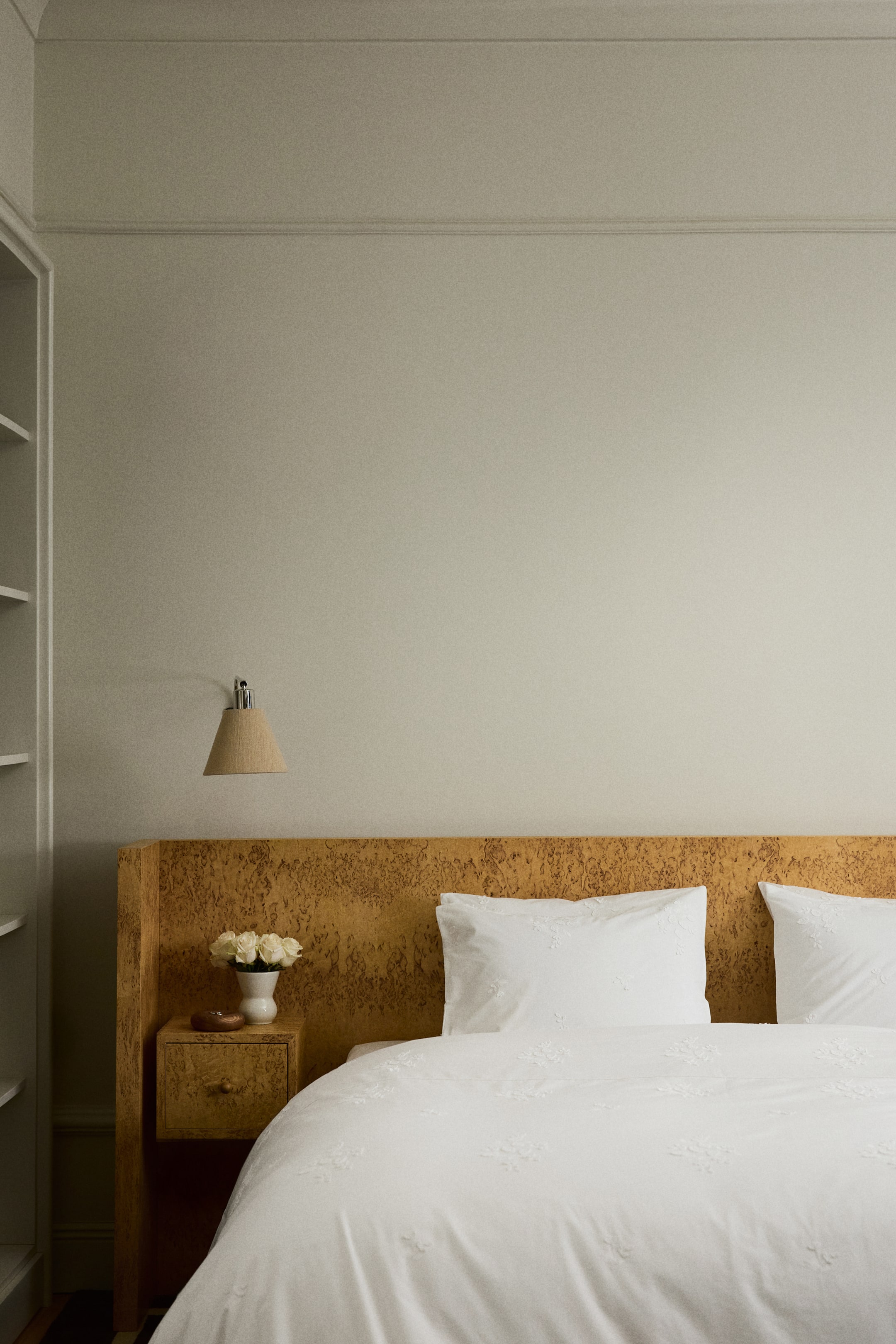 Ingrandisci l'immagine: Un set di biancheria da letto bianco copre un letto, composto da un piumone e due cuscini. Il piumone e i cuscini presentano un ricamo floreale delicato.