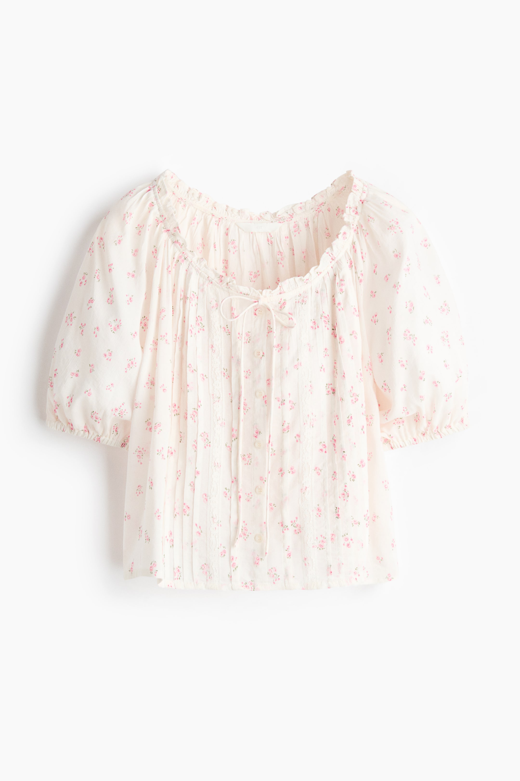 View larger image: A white blouse with a pink floral print is showcased from the front, featuring a frill-trimmed scoop neckline with gathers and narrow ties. Pintucks and lace trims embellish the front, where buttons are also visible, along with short puff sleeves with elasticated cuffs and a straight-cut hem.