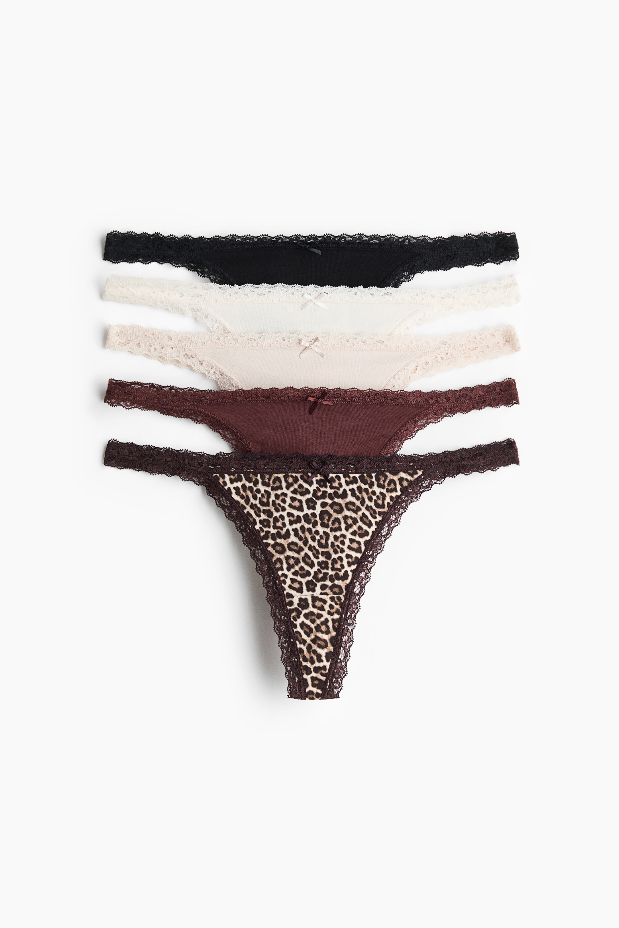 View larger image: Five G-strings in cotton jersey are arranged in a vertical stack, displaying the front design of each pair. The set features a mix of colours and patterns, including leopard print, dark brown, light beige, cream, and black, with each pair showing a low-rise waist, narrow lace sides, lace trims, and a small decorative bow at the centre.
