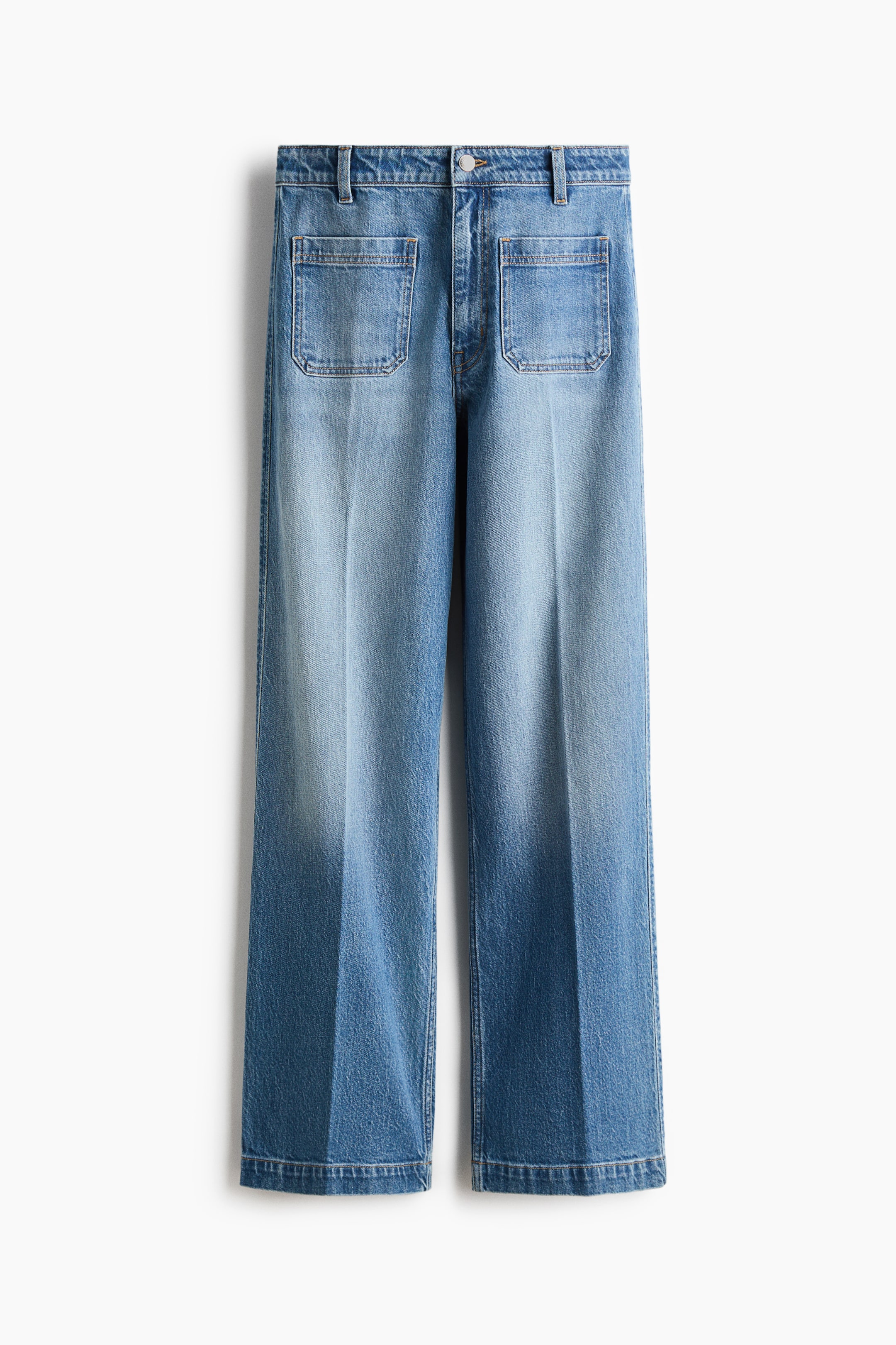 View larger image: Front-facing light-blue denim jeans feature a high waist with a button closure and two patch pockets. The wide-leg cut extends from the thigh to the hem, with distinct creases running vertically down the front of each leg.