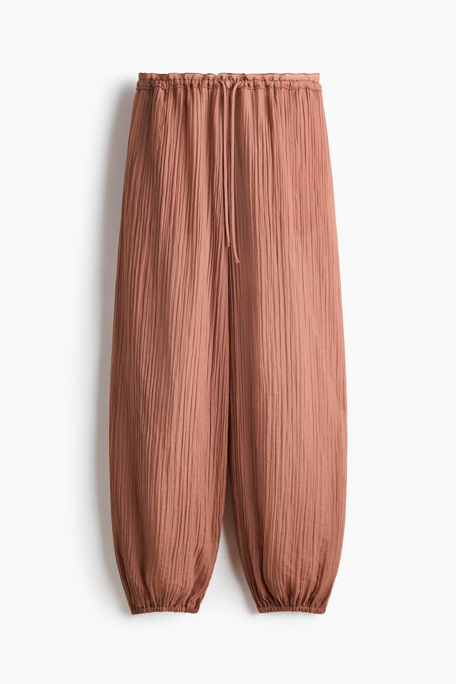 Die Terrakotta-Hose zeichnet sich durch eine geknitterte Textur, einen elastischen Kordelzugbund und geraffte, elastische B&uuml;ndchen aus und bietet eine lockere Passform.