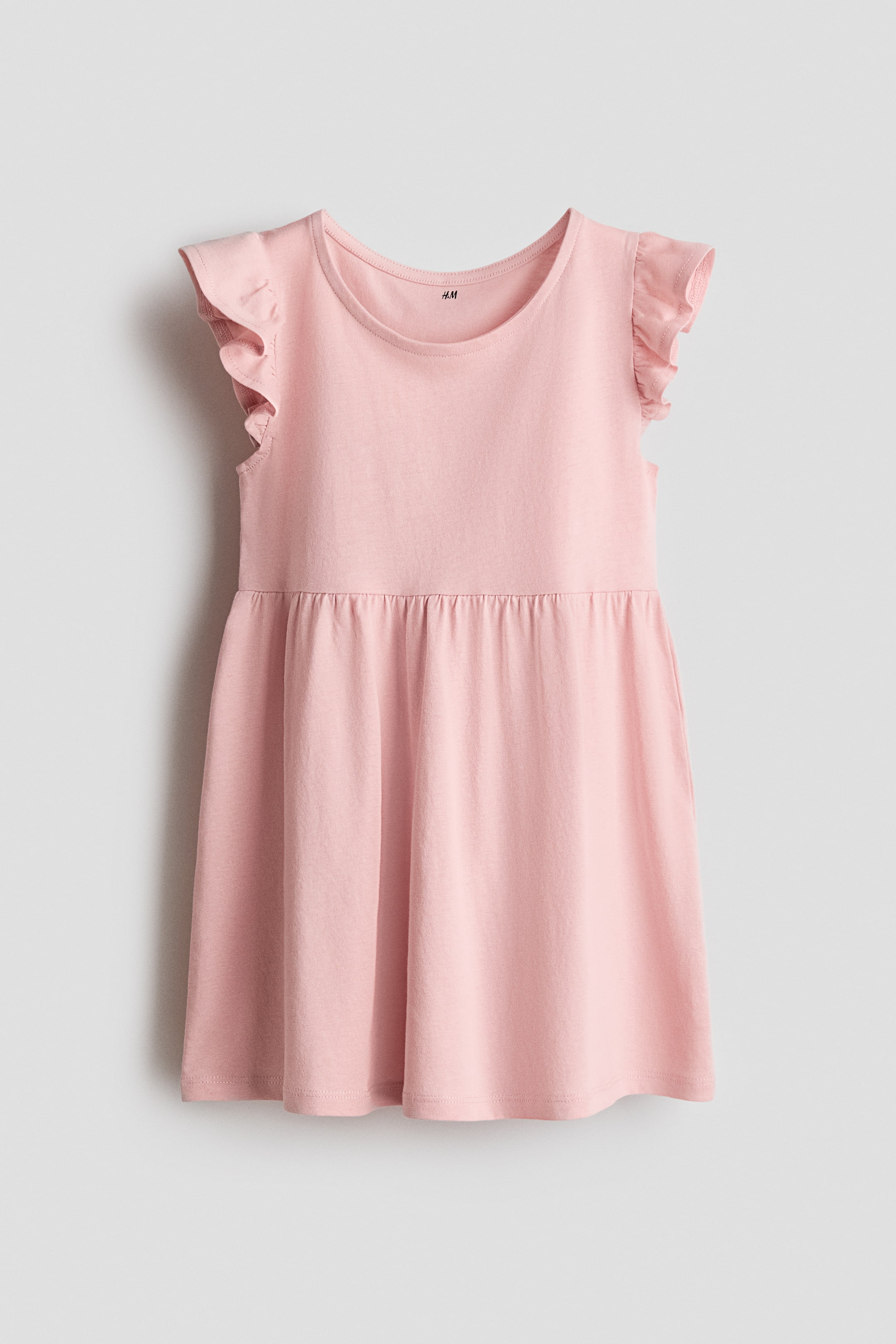 View larger image: A pink dress in soft cotton jersey is showcased from the FRONT, featuring a round neckline, flutter sleeves, and a gathered seam at the waist.